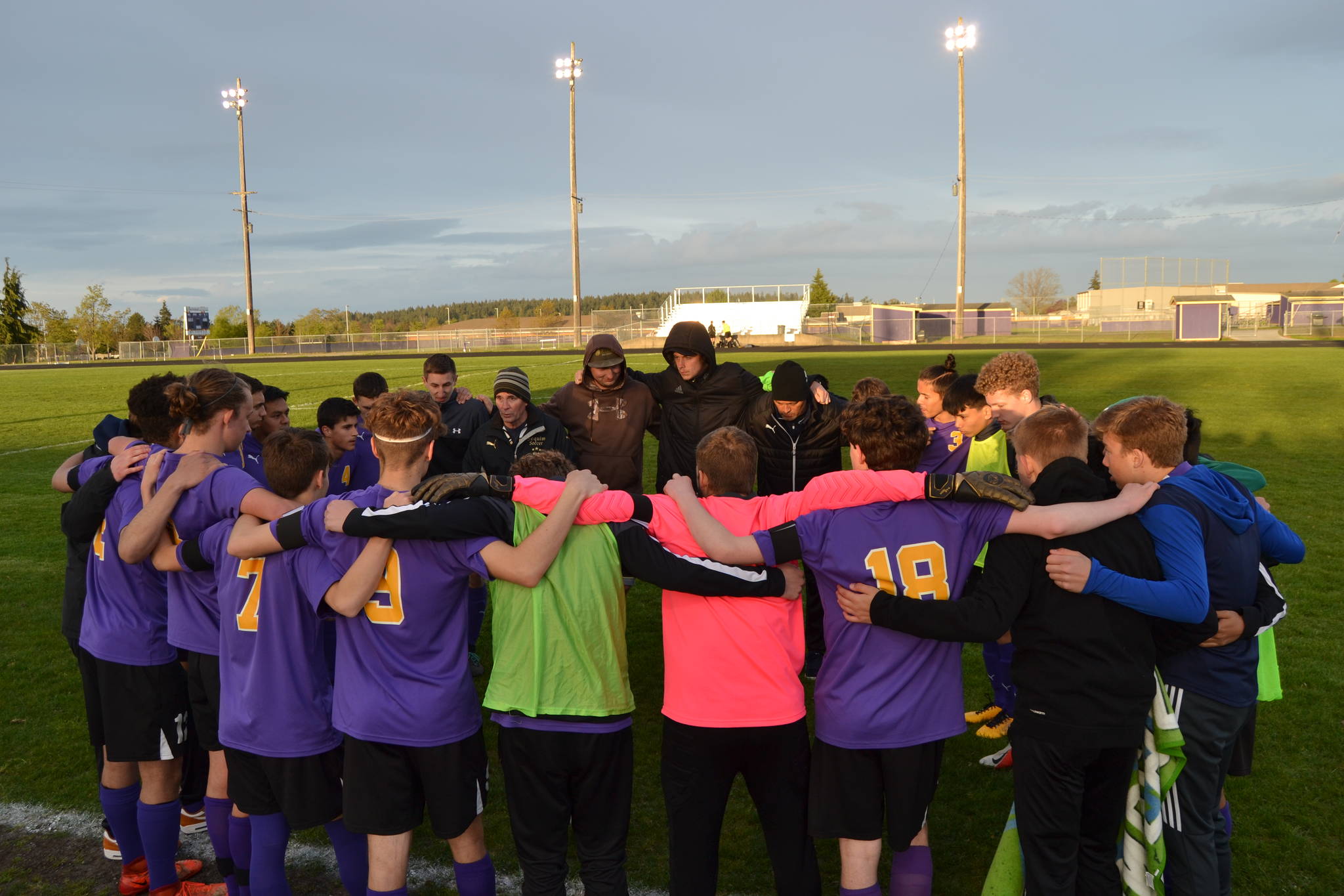 Sequim High School’s boys soccer team gathers at halftime during a spring 2019 league match. The stadium will be illumanted for 20 minutes at 8:20 p.m. (20:20 military time) on April 17 in honor of the spring prep athletes unable to complete their season after all state schools were closed in mid-March. Sequim Gazette file photo by Matthew Nash