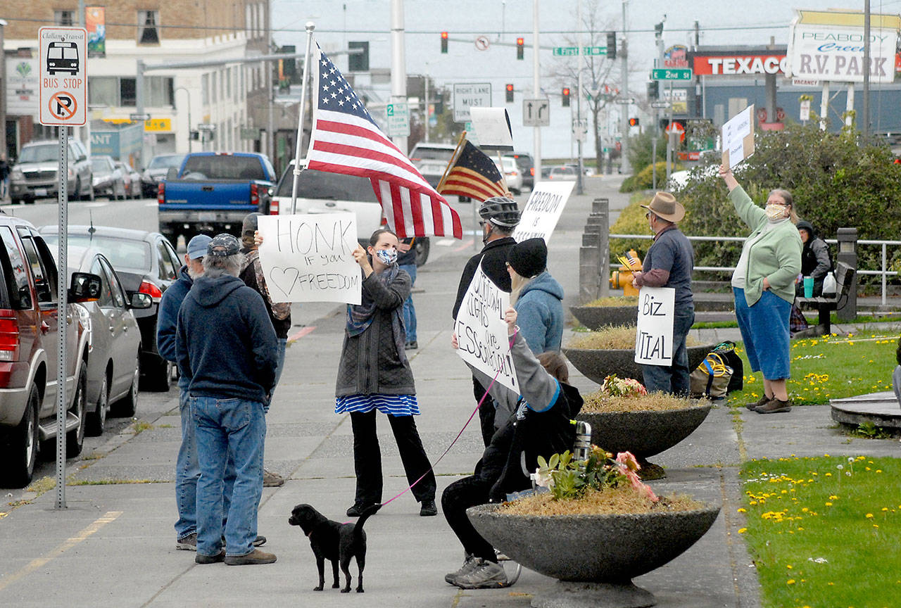A group of about a dozen people against the state’s stay-at-home directives to combat spread of COVID-19 wave signs and flags at a gathering on Thursday, April 23, at Veteran’s Park in Port Angeles. Photo by Keith Thorpe/Olympic Peninsula News Group