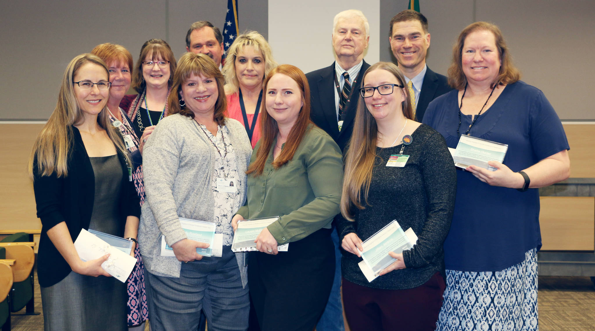 Pictured are (back row, from left) Rhonda Bowen (director, safety program and medical staff services), Stacy Remick, Chief Medical Officer Dr. Scott Kennedy, Marisa Bleck, OMC board president Jim Leskinovitch and Chief Operating Officer Darryl Wolfe, with (from row, from left) Mika Nel, Sally Rowland, Lauren McElwain, Jillian Jenkins and Shellie Hunter. Photo courtesy of Olympic Medical Center