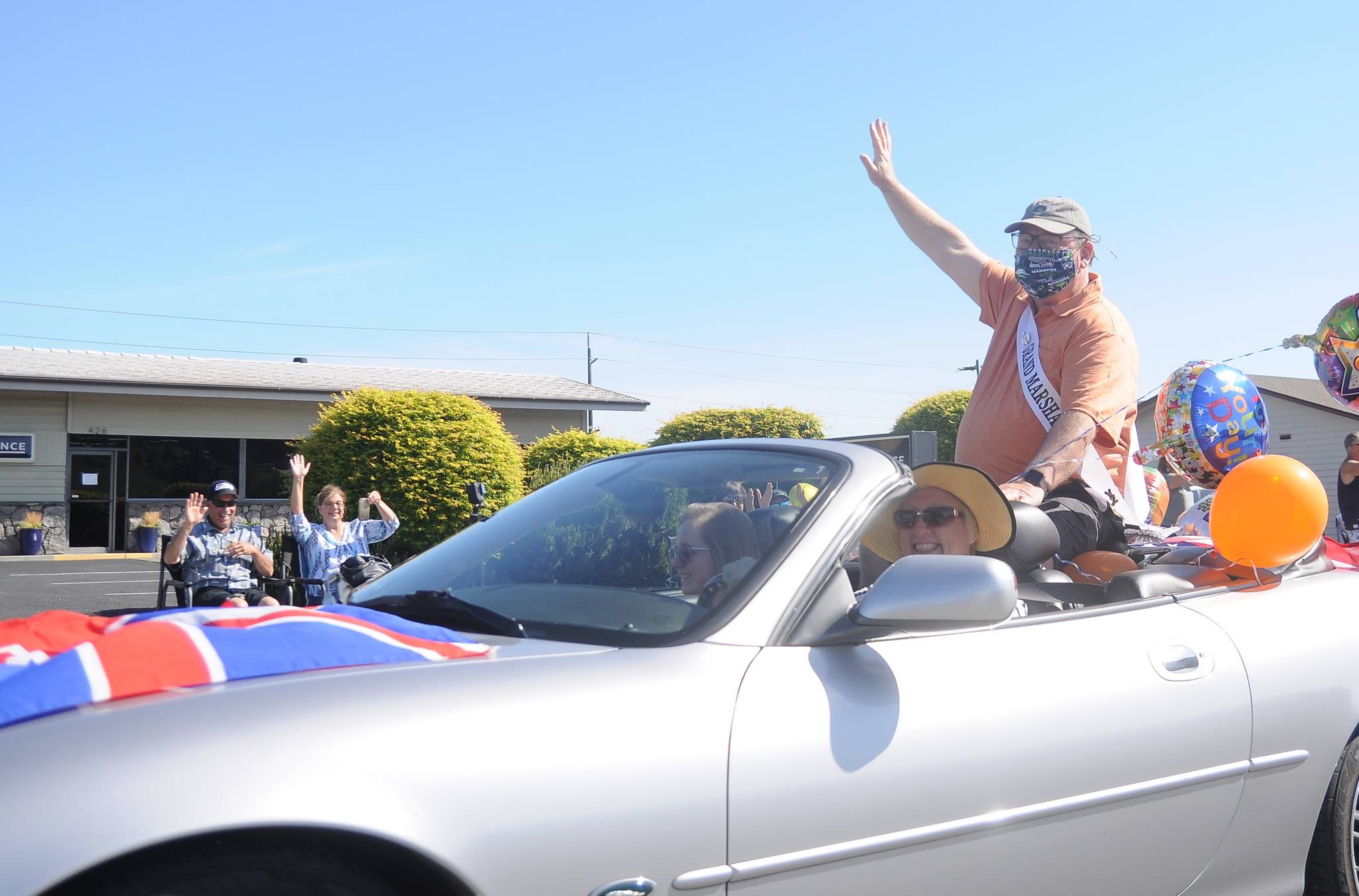 Phil Castell, the 2020 Irrigation Festival Grand Parade marshal, waves to a small gathering on what would have been the festival’s parade day on May 9. With the festival postponed until October, Castell hosted the small, one-car parade to mark the original day of the Grand Parade. Sequim Gazette photo by Michael Dashiell