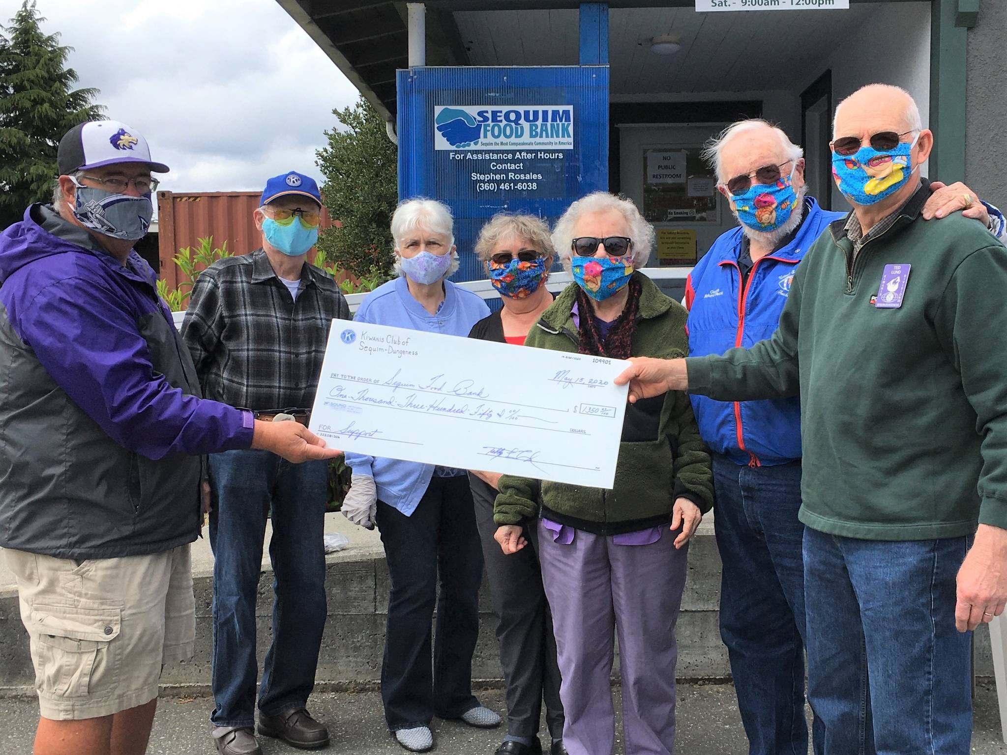 At right, Ted Lund, treasurer of the Kiwanis Club of Sequim-Dungeness, presents a donation to Stephen Rosales of the Sequim Food Bank (at far left). Also in attendance are, from second-to-left, club members Wayne Boden (president), Mary Boden, Philomena Lund (secretary), Janice Teeter and Richard Fleck (past president). Submitted photo