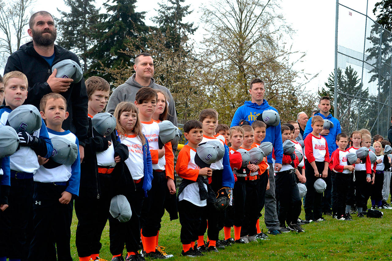 Players and coaches stand for The Star Spangled Banner at Sequim Little League’s opening day ceremony in April 2019. This year’s season has been cancelled with concerns of the spread of the 2019 novel coronavirus. Sequim Gazette file photo by Matthew Nash