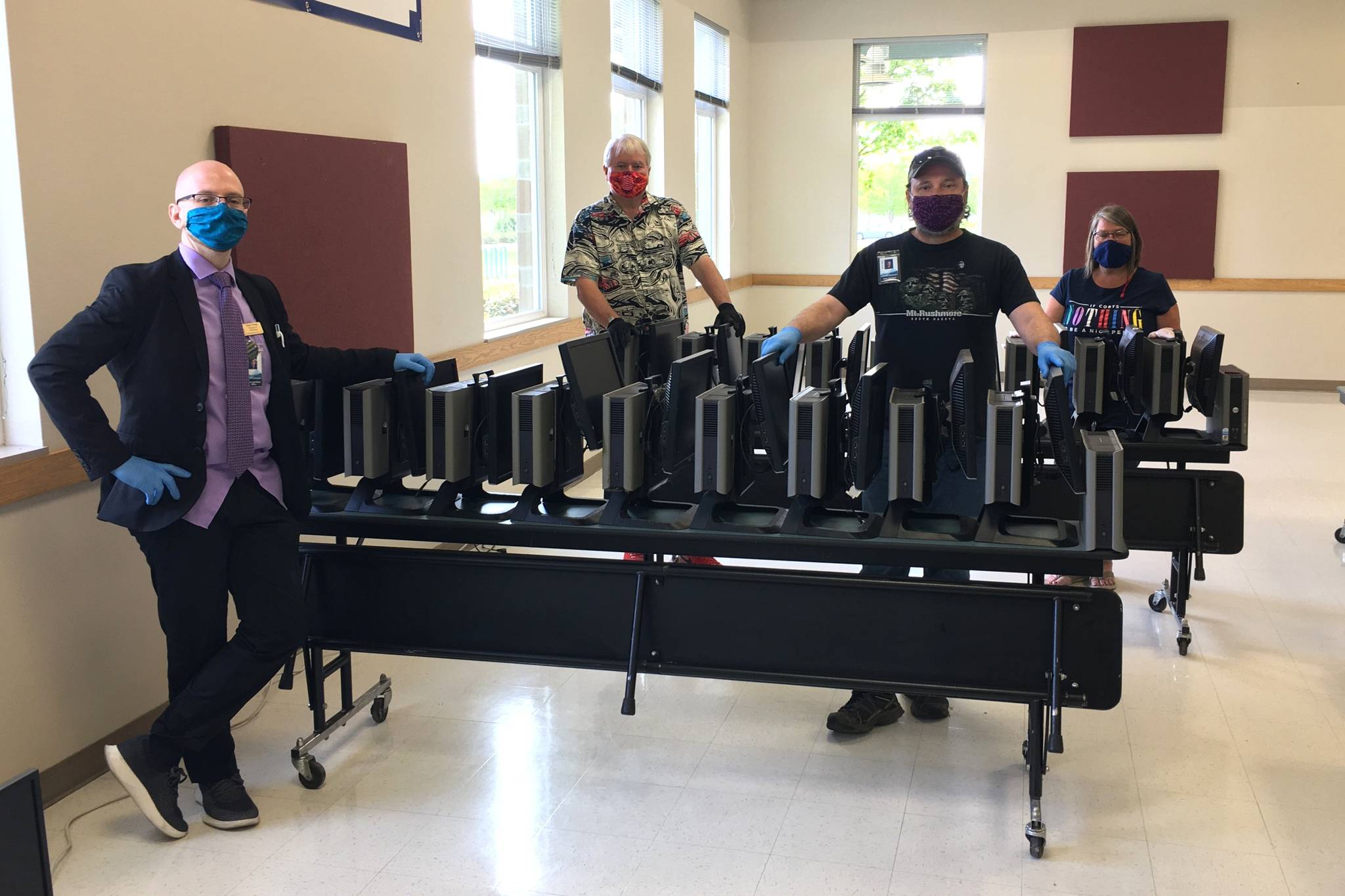 With refurbished computers donated by the Sequim PC Users Group, Sequim School District’s IT staff, from left, Director Beau Young, Richard Seiler, Scott Harmsen and Maria Seabolt helped distribute more than 100 computers for families without the technology in their homes to participate in distance learning for grades 6-12. Sequim Gazette photo by Matthew Nash