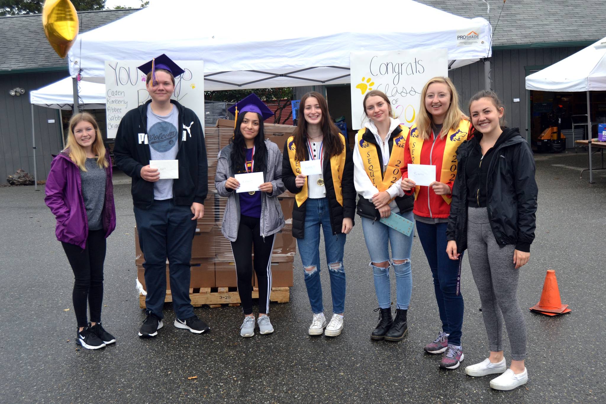 On June 20, JoNell Hill, far left, and Ashley Rosales, far right, presented $100 each on behalf of Stephen and Kim Rosales to recent Sequim High School graduates, from second left, Caden Habner, Kimberly Perez, Abbee Jagger, Gabby Happe, and Brianna Cowan for spending Saturday mornings at the Sequim Food Bank as volunteers. Sequim Gazette photo by Matthew Nash