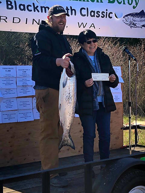 Brandon Leeper of Bellingham receives the first place $10,000 prize money for winning the 2020 Olympic Peninsula Salmon Derby from Kathy Watrous, President of the Gardiner Salmon Derby Association. After state officials closed the 2020-21 winter salmon season Marine Areas 6, 7 and 9. The Gardiner Salmon Derby Association’s board agreed to call off the 2021 derby. Submitted photo