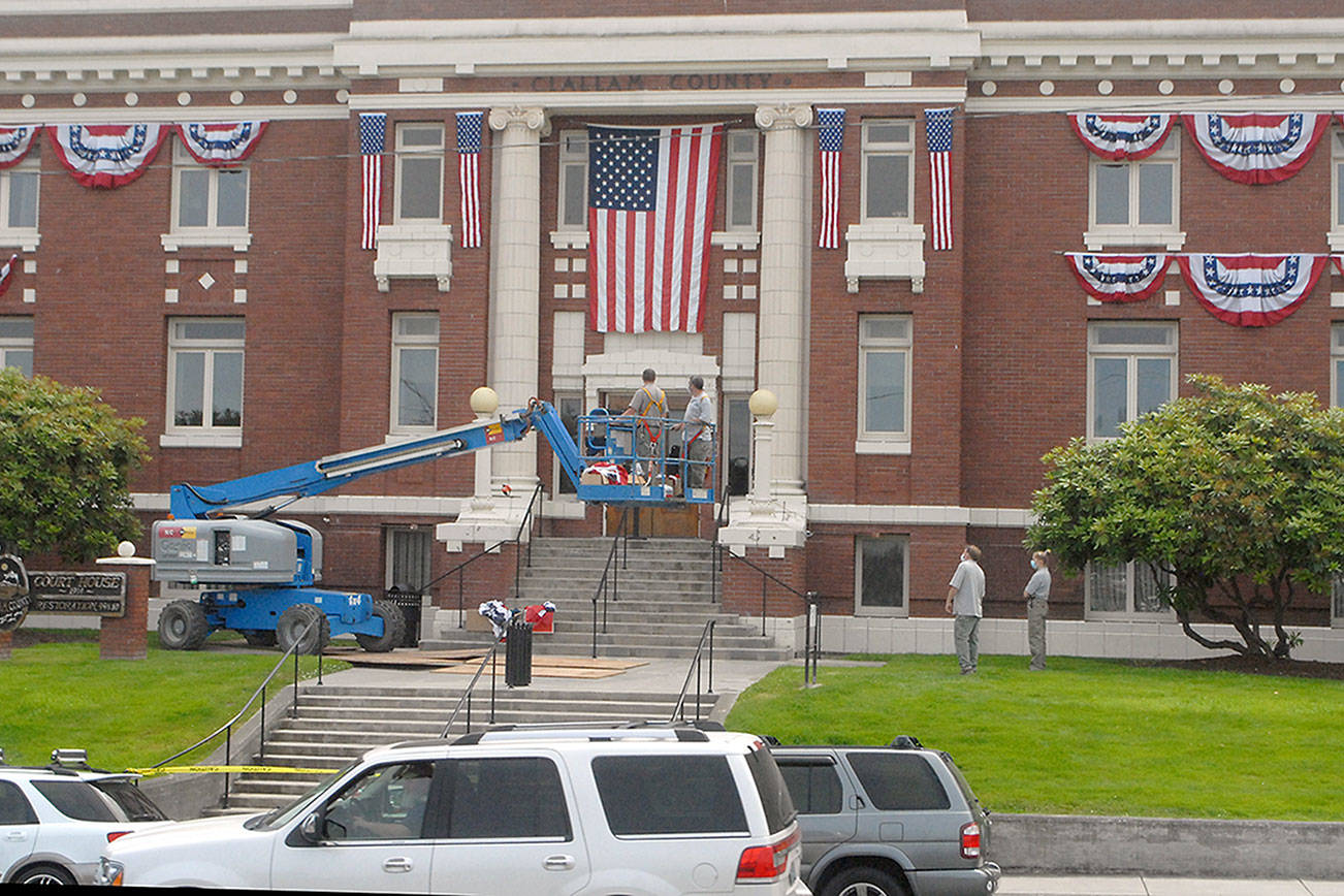 Clallam County Courthouse workers hang bunting on the front of the historic Port Angeles courthouse on Wednesday in honor of Independence Day. Photo by Keith Thorpe/Olympic Peninsula News Group