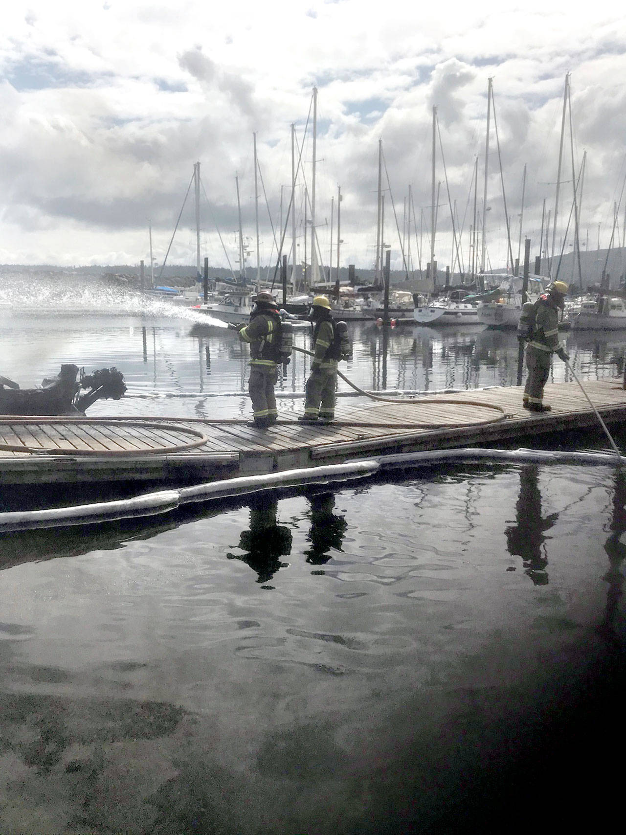 Clallam County Fire District No. 3 firefighters Chad Cate, Colton McGuffey and Bo Pinnel fight a boat fire at John Wayne Marina Saturday morning. Photo courtesy of Clallam County Fire District No. 3                                Clallam County Fire District No. 3 firefighters Chad Cate, Colton McGuffey and Bo Pinnel fight a boat fire at John Wayne Marina Saturday morning. Photo courtesy of Clallam County Fire District No. 3