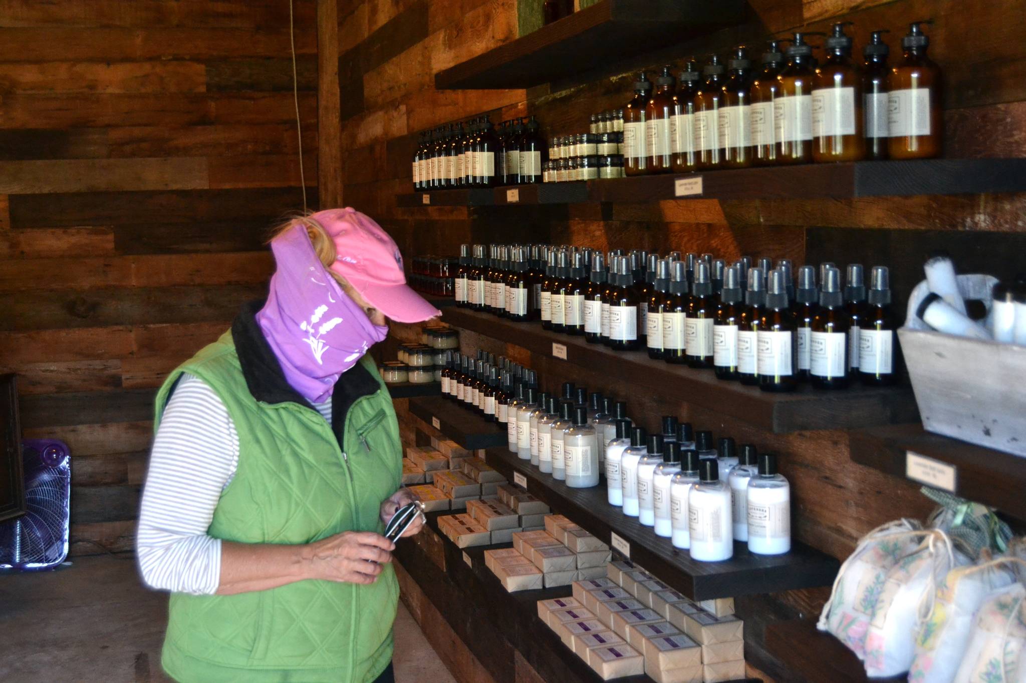 Shari Roland of Tacoma looks at some soaps during a visit to Lavender Connection’s gift shop. Lavender farms must require visitors and staff to wear masks inside buildings and recommend them in lavender fields, Clallam County health officials say. Sequim Gazette photo by Matthew Nash