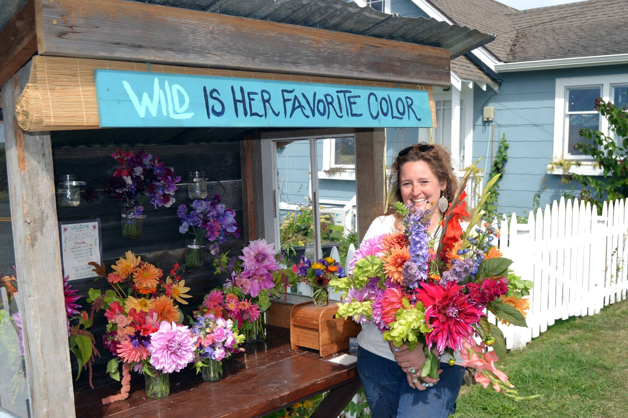 Mikel Townsley’s flower stand “Wild is Her Favorite Color” has become a popular attraction on Cays Road since going up on July 5. She planted more than 700 starts this year as a project to help channel her energies after working at the Olympic Medical Cancer Center. “I want to put my hands in the dirt and create something for these people,” she said. 
Sequim Gazette photo by Matthew Nash