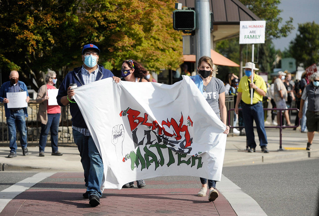 Carlos Osorio and Courtney Thomas carry a “Black Lives Matter” banner at the Sequim Avenue-Washington Street intersection during an Aug. 29 demonstration. Sequim Gazette photos by Michael Dashiell
