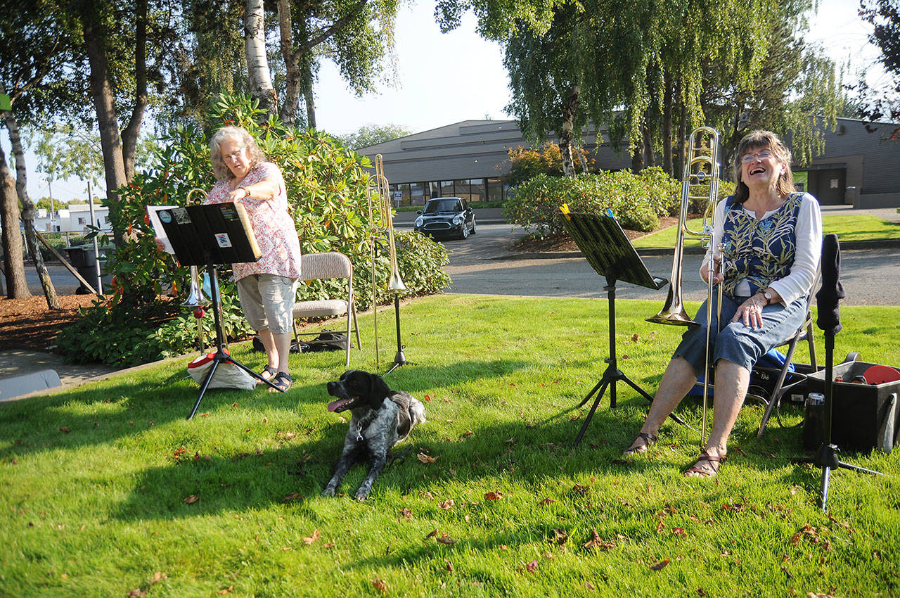 Bonnie Booth, left, and Cindy MacKay take a break from playing duets in the park near the intersection of Sequim Avenue and Washington Street in downtown Sequim on Oct. 2. Enjoying some of the tunes is Woody, a 9-month-old French Brittany Spaniel. Sequim Gazette photo by Michael Dashiell