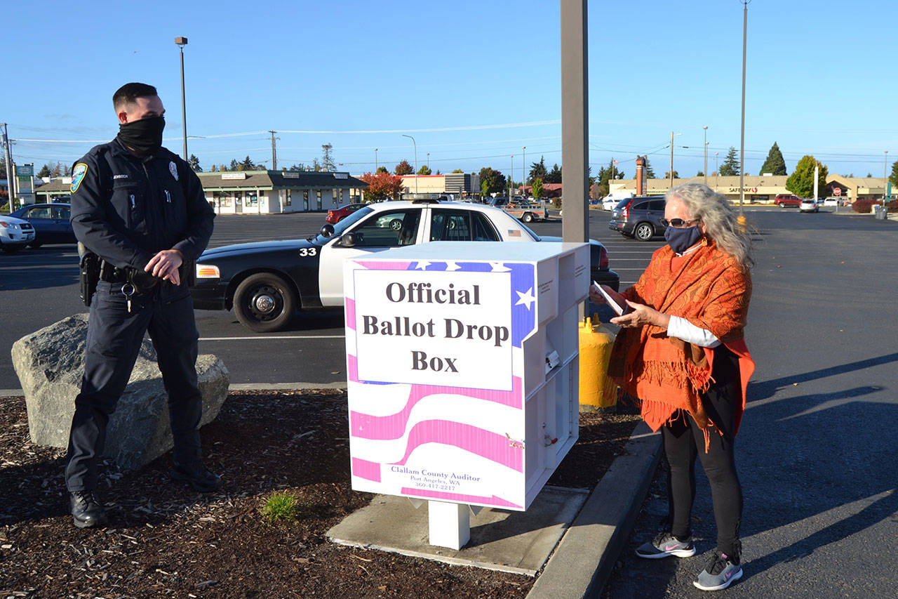 Leading up to the Nov. 3 general election, the Sequim Police Department increased its presence at the city’s lone ballot drop box at the Sequim Village Shopping Center, 651 W. Washington St. Here, Sequim Police Officer Taran Johnson speaks with Laraine Gau of Agnew after she drops off a ballot on Oct. 30. Staff Sgt. Sean Madison said they didn’t expect any issues on or after Election Day, but the department adjusted shifts to increase staffing during the day this week to be prepared for any possible situation. “We expect it to be a busy day,” he said. “Emotions can run high and we have a plan to deal with (Election Day) if anything goes funny on us, but we’re not seeing anything causing us concern.”Sequim Gazette photo by Matthew Nash