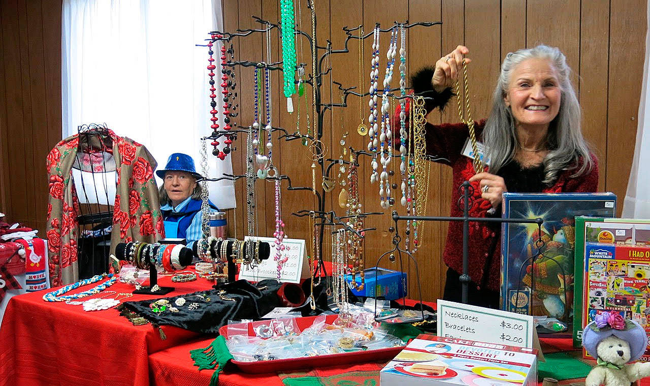 Barbara Tabor, left, and Janet McColl display items at the vintage/costume jewelry table at the Sequim Guild of Seattle Children’s Hospital’s Holiday Bazaar in 2019. This year’s event is set for Saturday, Nov. 21. Submitted photo