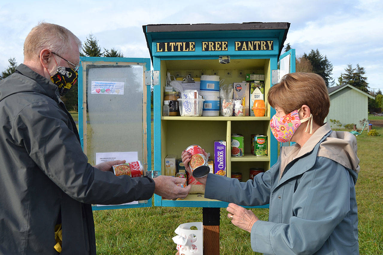 Sequim couple Greg and Vicki Sensiba work to stock the Little Free Pantry in front of the Olympic Unitarian Universalist Fellowship, 1033 Barr Road. Each day, fellowship volunteers restock the pantry with nonperishable items and toiletries for anyone to take. “It’s for anybody, and all ages,” Vicki said. “We don’t need to know if they are in-need or not.” Sequim Gazette photo by Matthew Nash