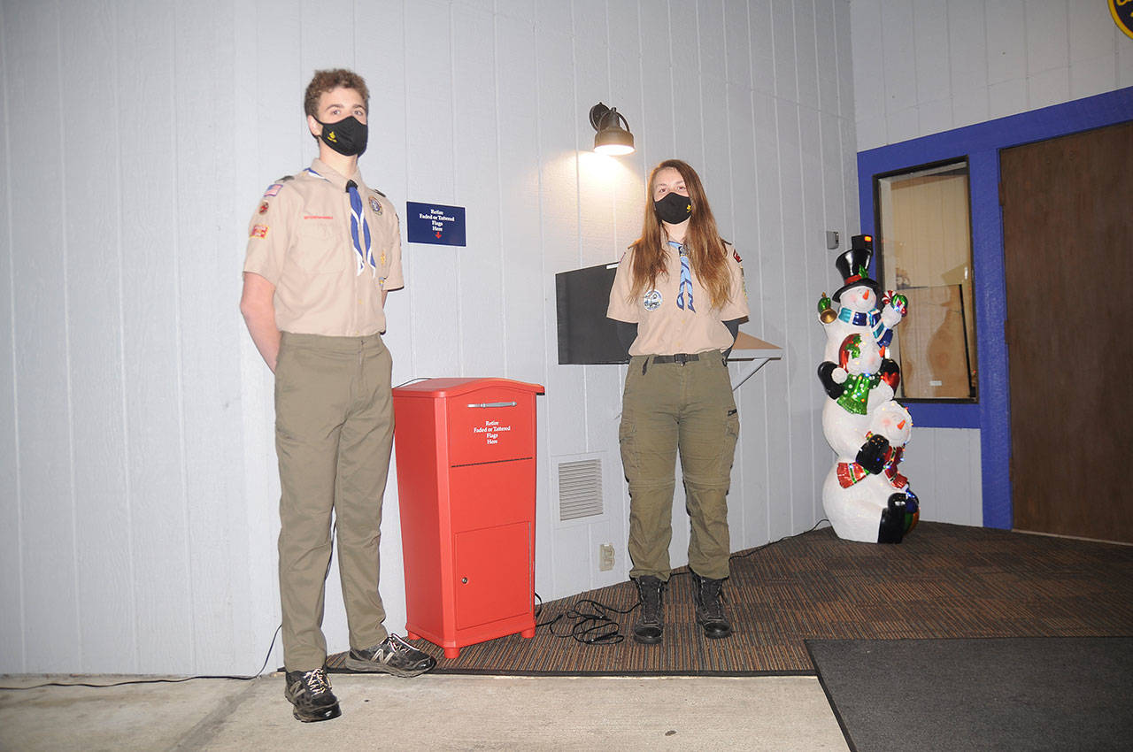Sam Stewart and Jenna Mason of BSA Troop 1498 last week display a newly-installed flag retirement box at the Sequim Elks Lodge, 143 Port Williams Road. Worn and weathered flags can be deposited here, where scouts will collect them and dispose of them properly. Sequim Gazette photo by Michael Dashiell