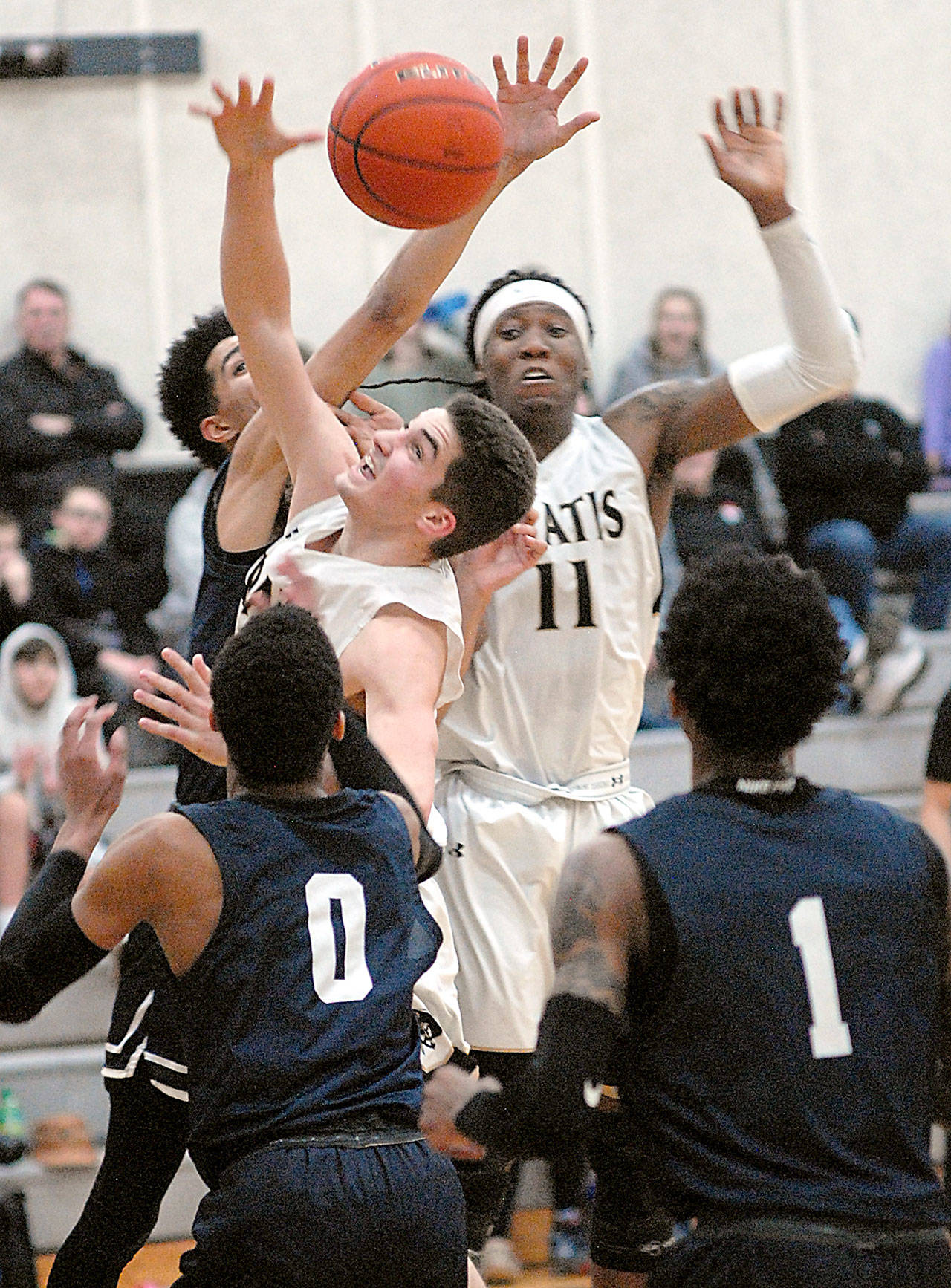 Peninsula College’s Nate Despain, center left, and Malik Moore, center right, fight for a rebound surrounded by Bellevue defenders Trey Lawrence, back, Trevon Richmond, front left, and Tijohn Rodde, front right, in February at Peninsula College in Port Angeles. Despain, a 2019 Sequim High grad, and the Pirates saw their 2020-2021 season pushed back to March 1. File photo by Keith Thorpe/Olympic Peninsula News Group