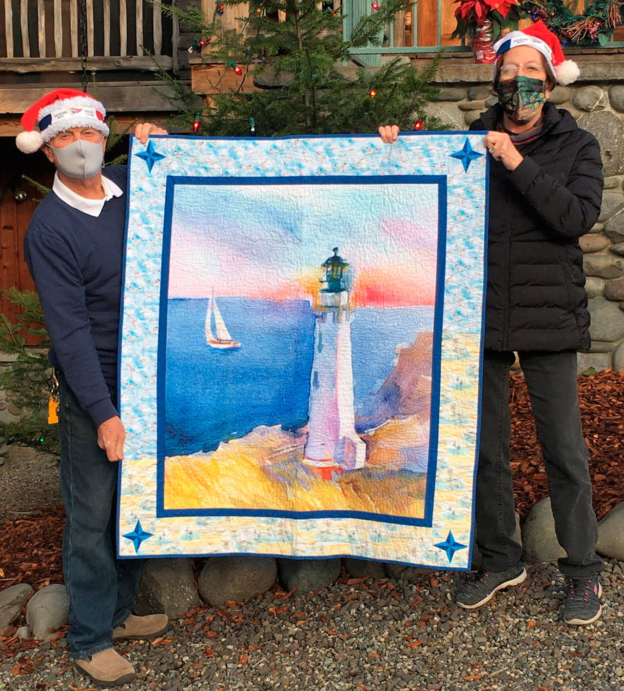 Beverly Nelson receives the Sequim Bay Yacht Club’s 2020 hospice quilt raffle in early December from commodore Jerry Fine. Submitted photo