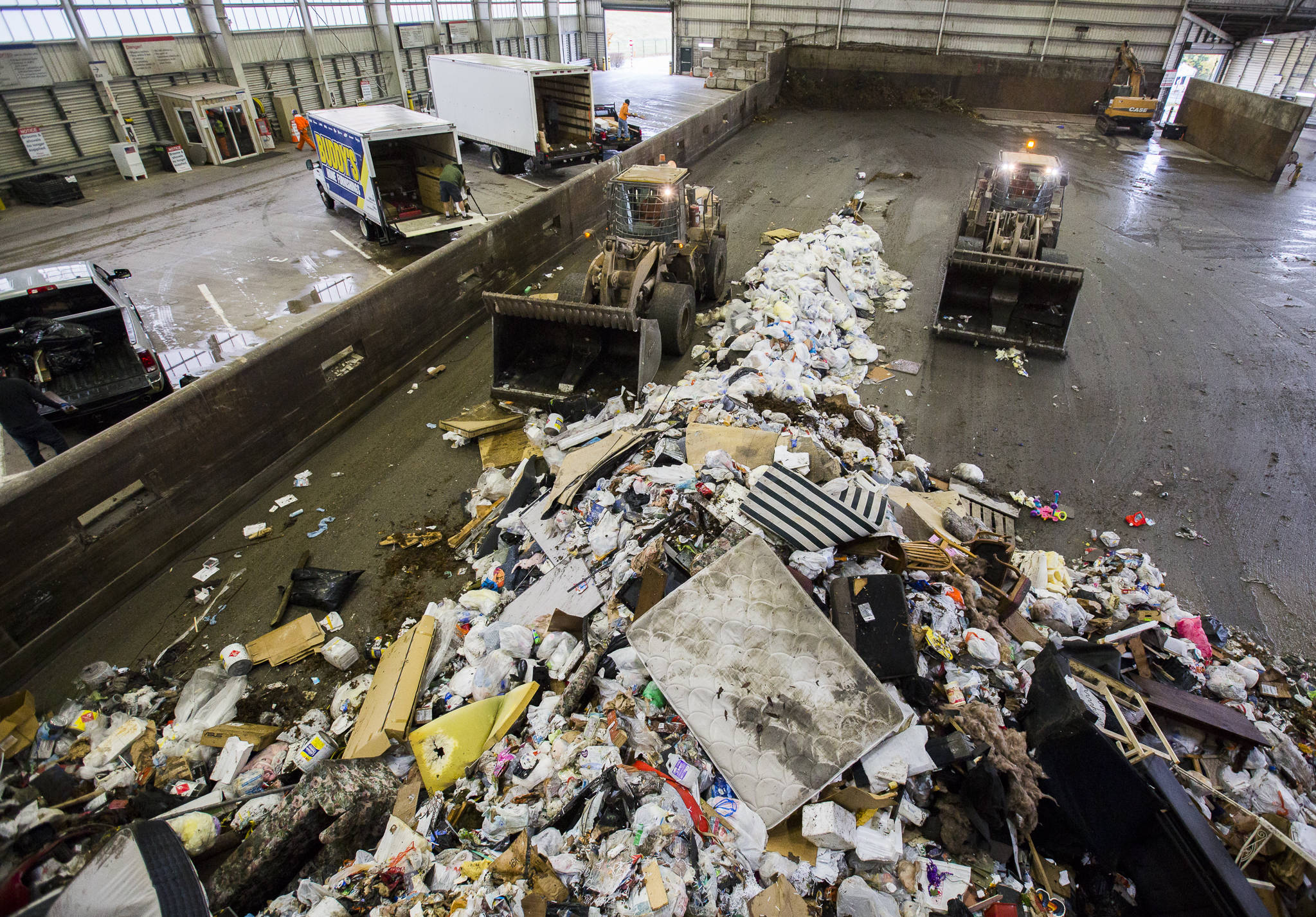 Front loaders push trash forward into one of the compactors at the Airport Road Recycling & Transfer Station on Nov. 24 in Everett. Photo by Olivia Vanni/The Herald (Everett)