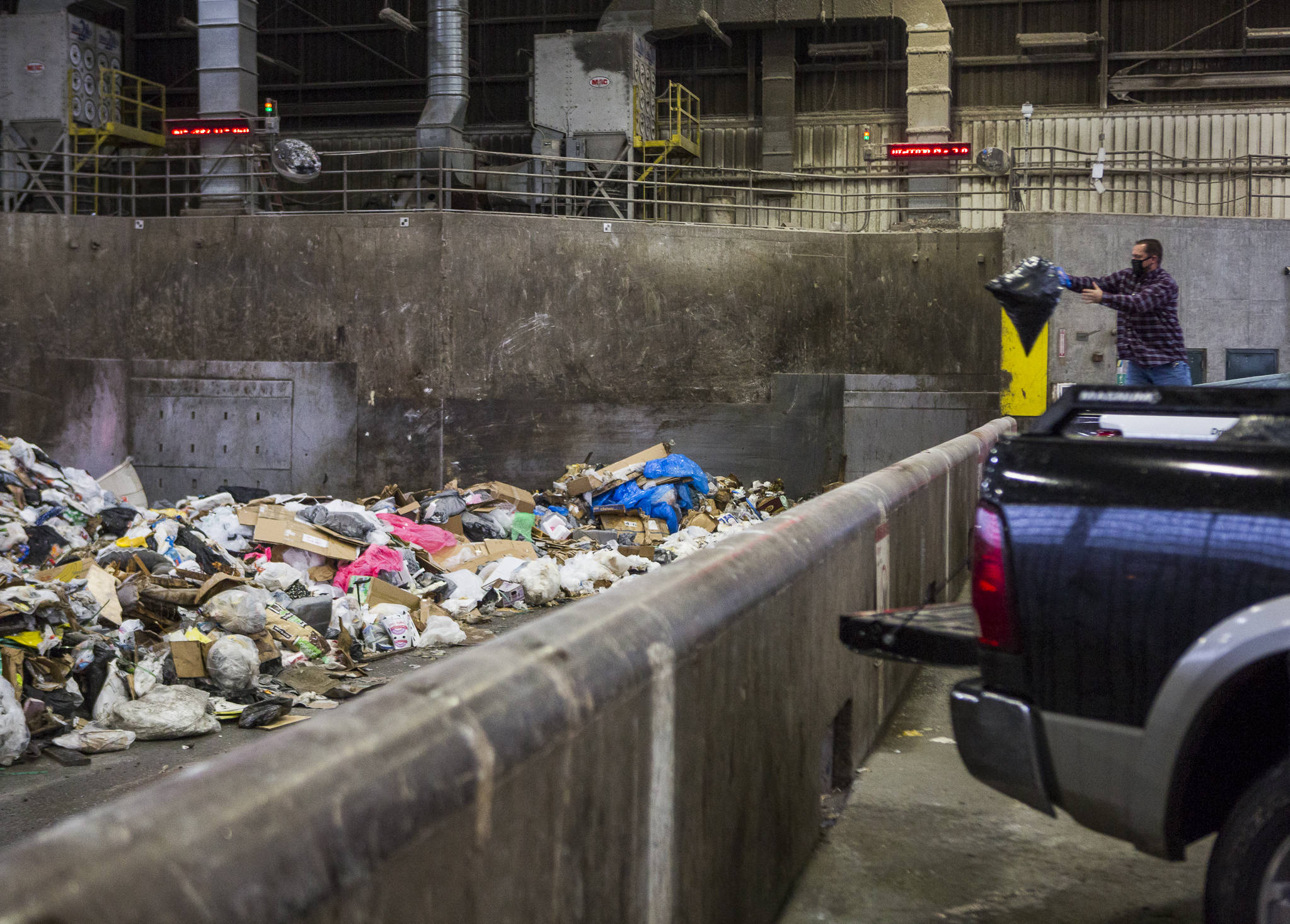 People throw their trash onto the tipping floor to be loaded into a compactor at the Airport Road Recycling & Transfer Station on Nov. 24 in Everett. Photo by Olivia Vanni/The Herald (Everett)