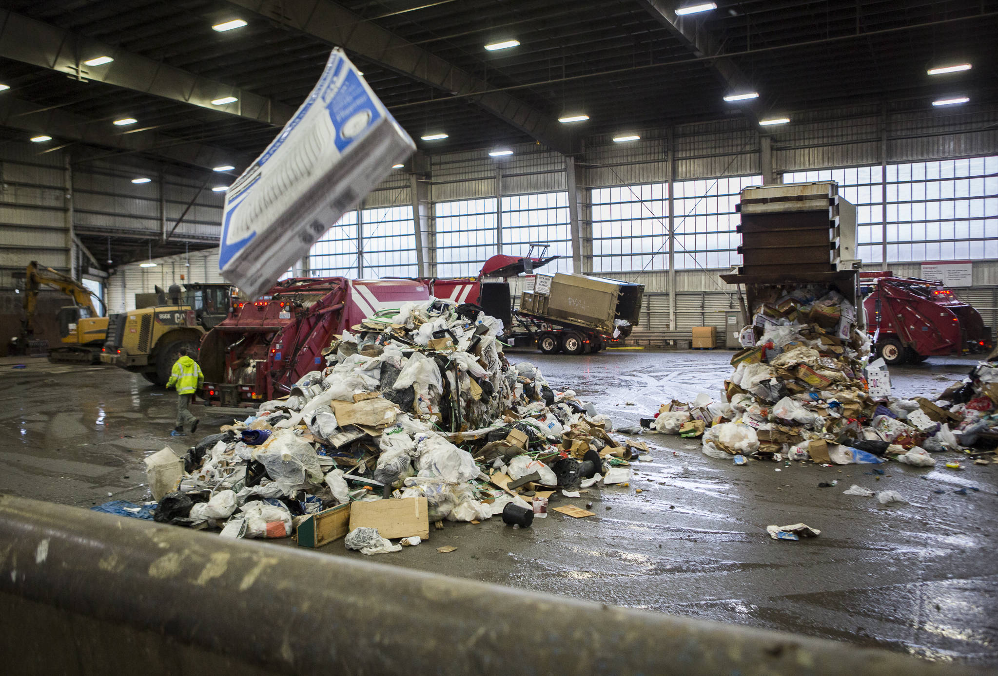 Garbage trucks dump trash onto the tipping floor at the Airport Road Recycling & Transfer Station on Nov. 24 in Everett. Photo by Olivia Vanni/The Herald (Everett)