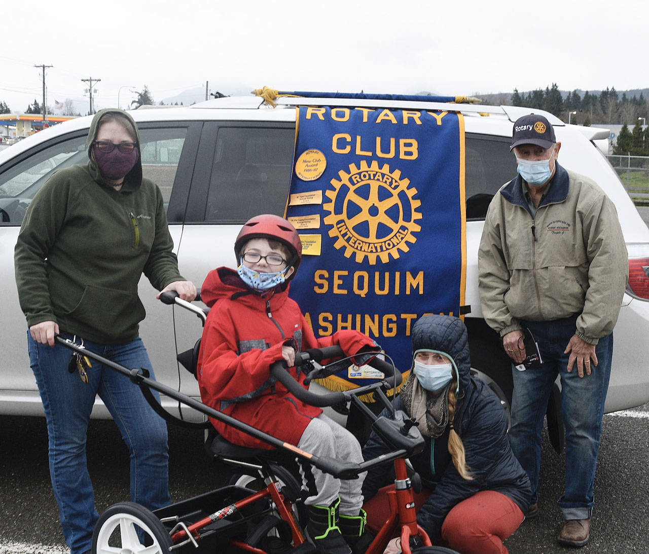 Seamus Sexton of Sequim enjoys his new adaptive tricycle. Pictured with Sexton are, from left, 
Zoey Wolfe, Molly Booth and 
Jim Jones. Photo by Doug Schwarz