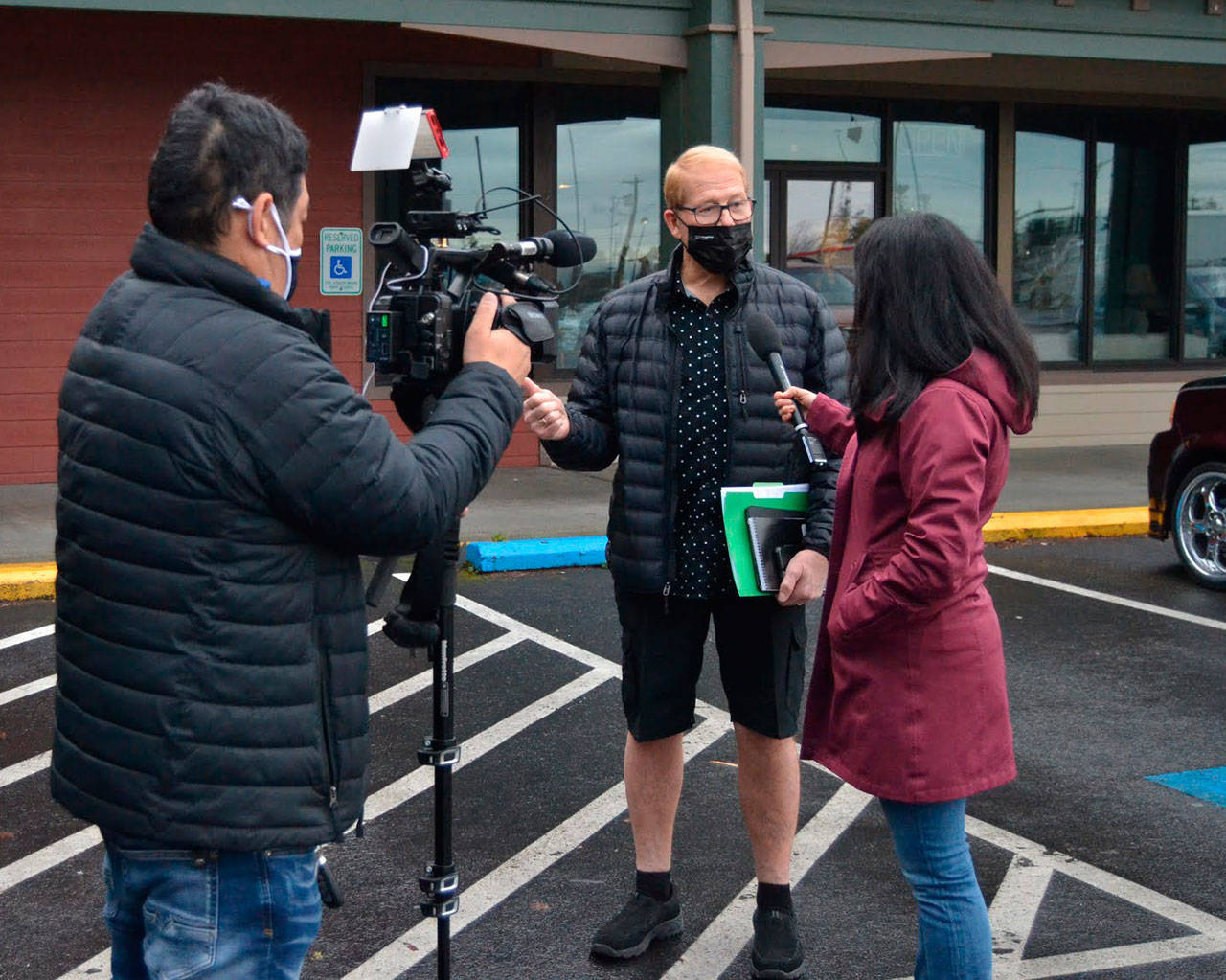 CNN photojournalist Taka Yokoyama and Kyung Lah, senior national correspondent, interview Sequim mayor William Armacost after a Coffee with the Mayor session Thursday morning in downtown Sequim. The reporters are in town through Friday talking with him and locals about QAnon. CNN’s segment was tentatively scheduled to air on Friday night. Sequim Gazette photo by Matthew Nash