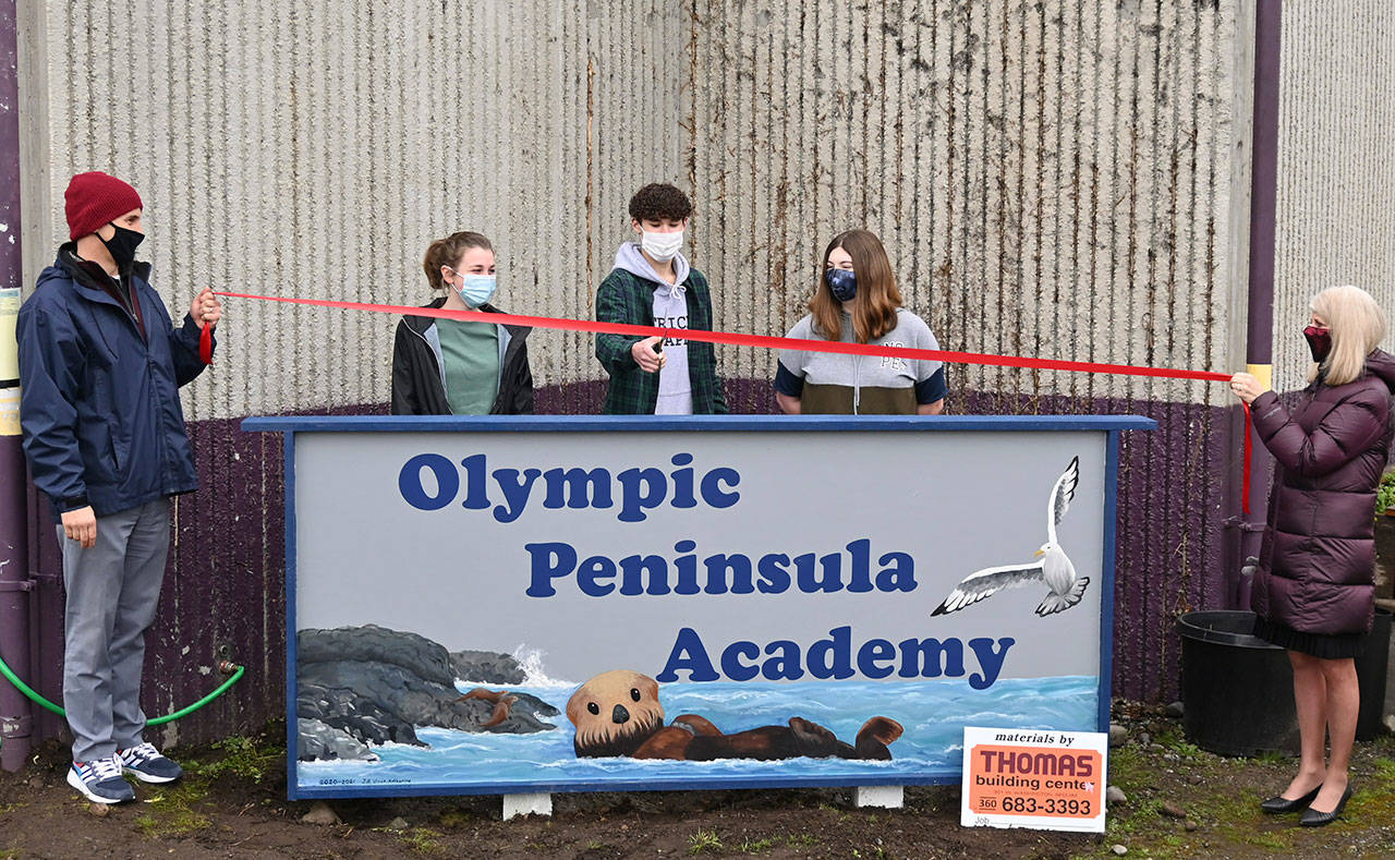 From left, Olympic Peninsula Academy principal Vince Riccobene, OPA students Katherine Gould, Vincent Carrizosa and Jill Adolphsen, and interim superintendent Jane Pryne celebrate the addition of OPA’s newly constructed sign on Feb. 4. Sequim Gazette photo by Michael Dashiell