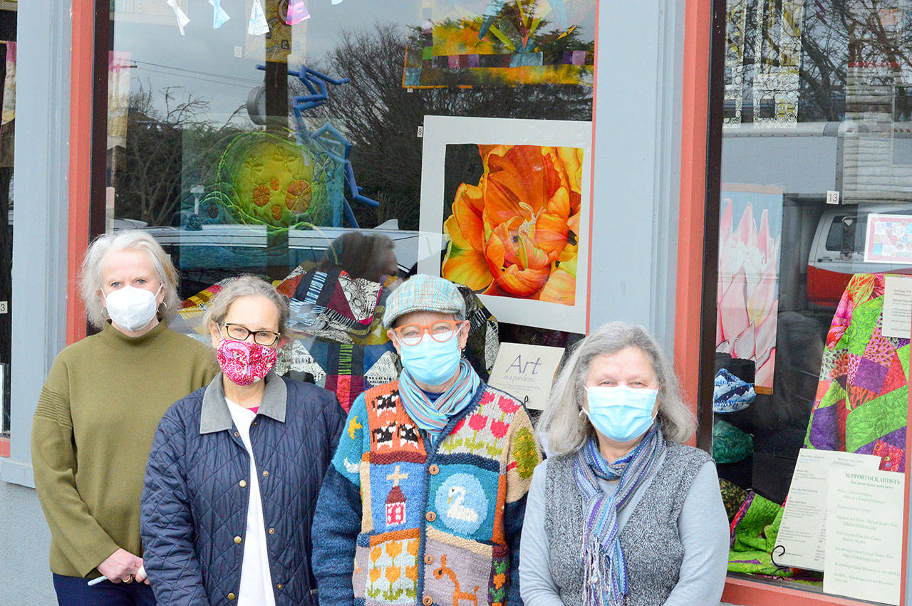 At the display window in Uptown Port Townsend are, from left, Jeri Auty, Cheri Kopp, Debra Olson and Sue Gale, contributors to the “Art in a Pandemic” show, on view around the clock at the corner of Tyler and Lawrence streets. Photo by Diane Urbani de la Paz/Olympic Peninsula News Group