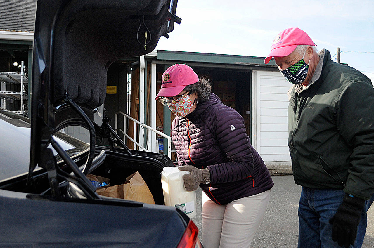 Sequim Sunrise Rotary members Ann Flack and Russ Mellon help load a car at the Sequim Food Bank on March 8. Last year, visitations and food served has nearly doubled compared to 2019 due to the pandemic while demand remains high so far in 2021, food bank leaders report. Sequim Gazette photo by Matthew Nash