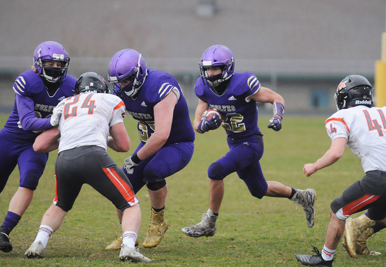 Sequim running back Walker Ward gets some key blocking from Brandon Barnett (55) in the first half of Sequim’s season finale against Central Kitsap on March 18. Ward had 62 yards in the 38-22 victory. Sequim Gazette photo by Michael Dashiell