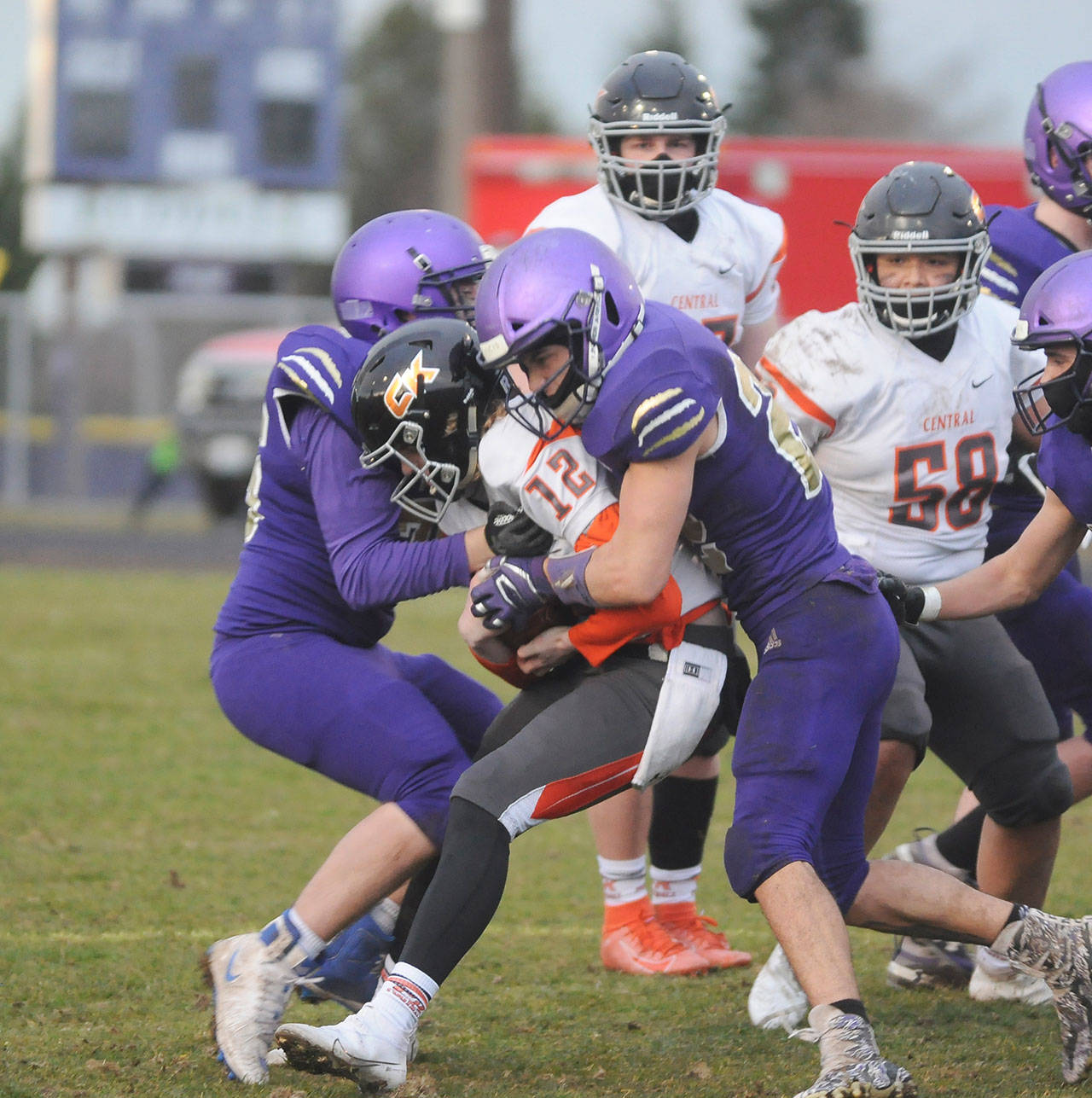Sequim’s Faas Christiansen, left, and Walker Ward sandwich Central Kitsap’s Ryder Wright during the Wolves’ 38-22 win over the Cougars. Sequim Gazette photo by Michael Dashiell