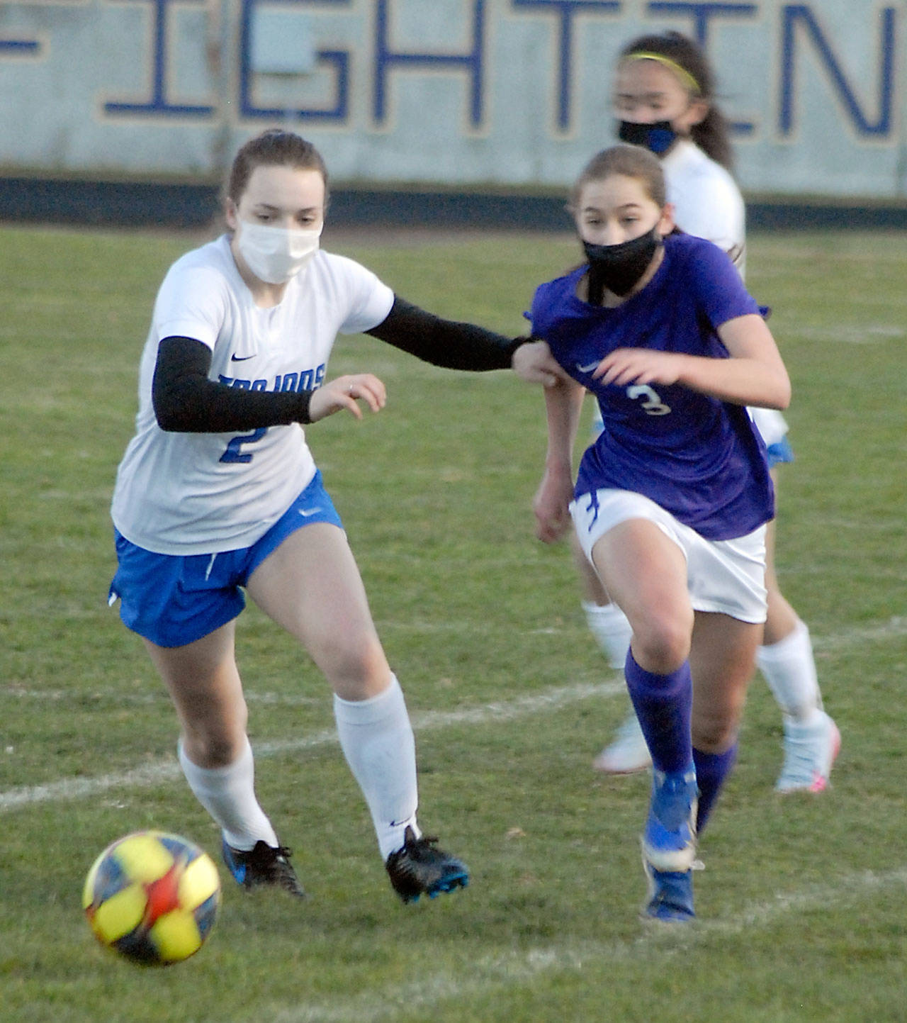Olympic’s Claire Caldwell, left, races for the ball with Sequim’s Taryn Johnson in the first half at Sequim High School on March 16. Photo by Keith Thorpe/Olympic Peninsula News Group