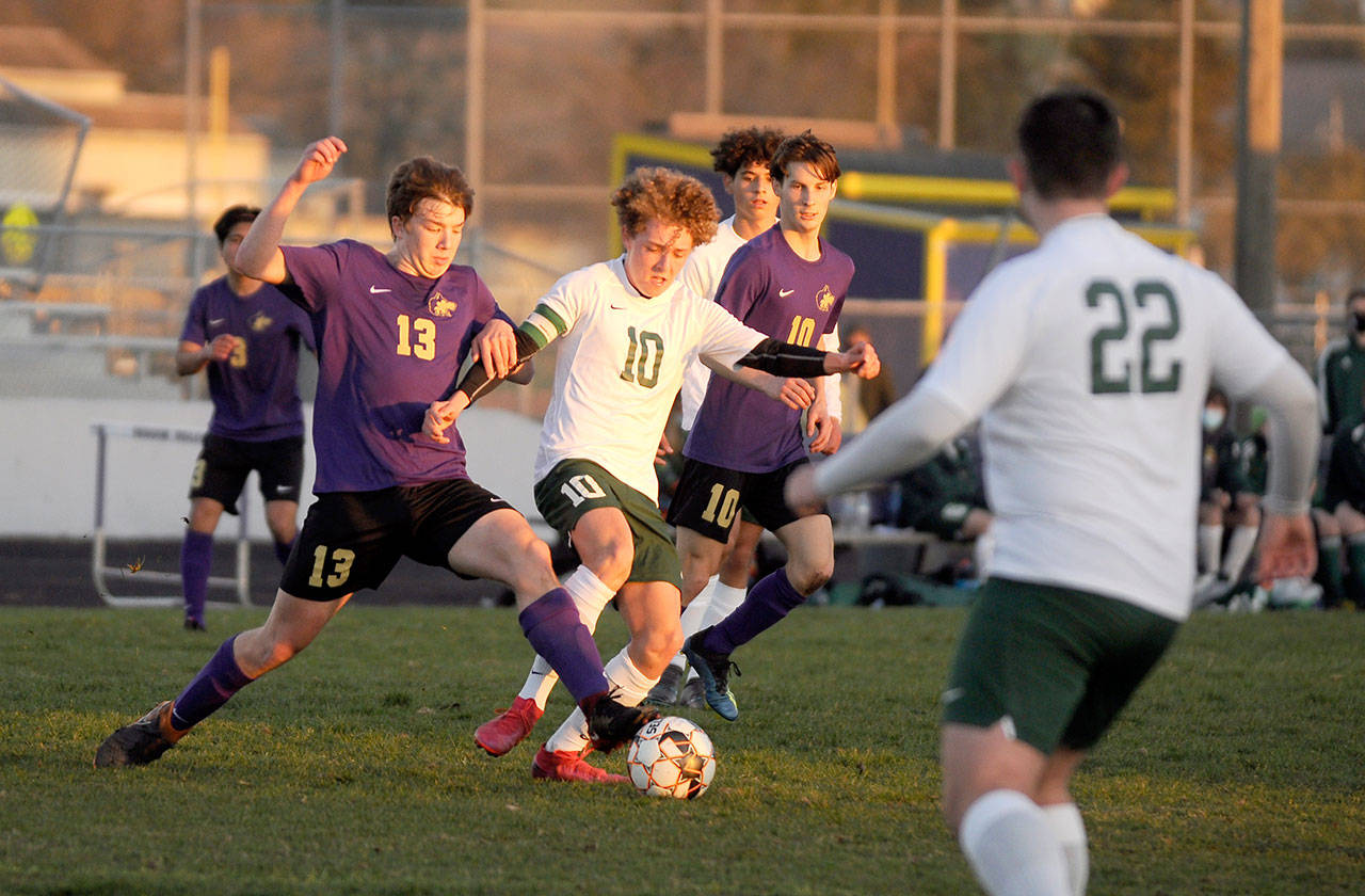 Sequim’s Brandon Charters, left, and Port Angeles’ Damon Gunderson vie for possession in a March 25 match in Sequim. The host Wolves shut out their cross-peninsula rivals, 2-0. Looking on are Sequim’s Eli Gish (13) and Port Angeles’ Dominick Fischer (22). Sequim Gazette photo by Michael Dashiell