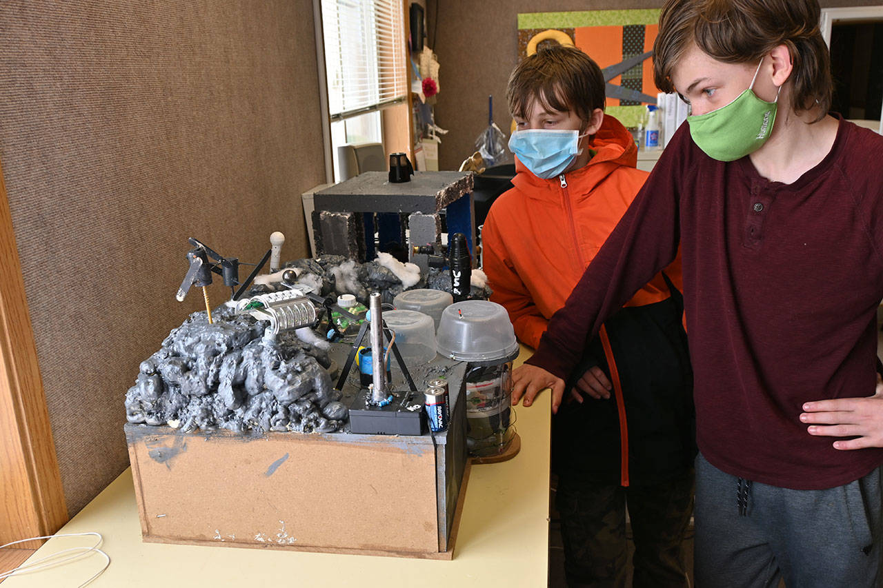 Donovan Rynearson, left, and Mica McCarter look over their Future City creation at Olympic Peninsula Academy last week.