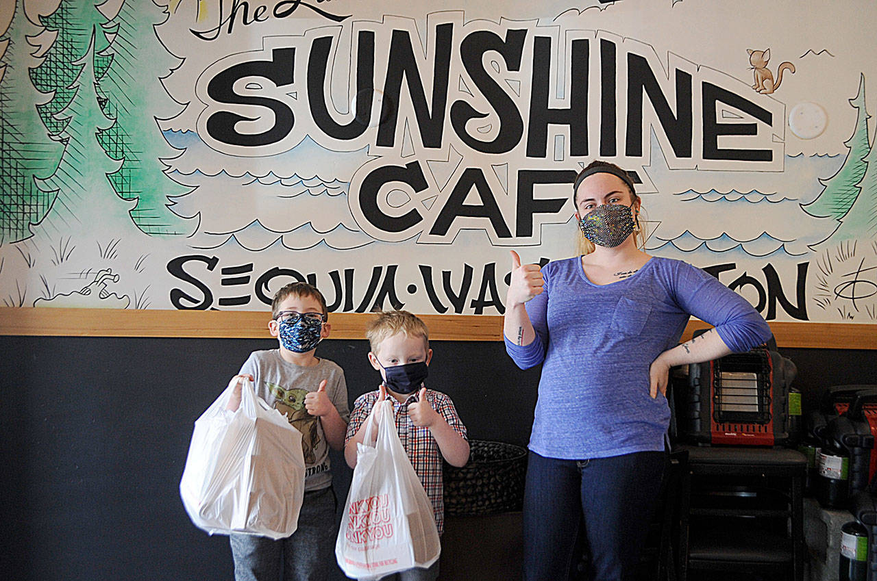 Reporter Matthew Nash’s boys take a photo with Sunshine Café server Megan Sias during a recent scavenger hunt across the area. This is her first appearance in a newspaper, she said. Sequim Gazette photo by Matthew Nash