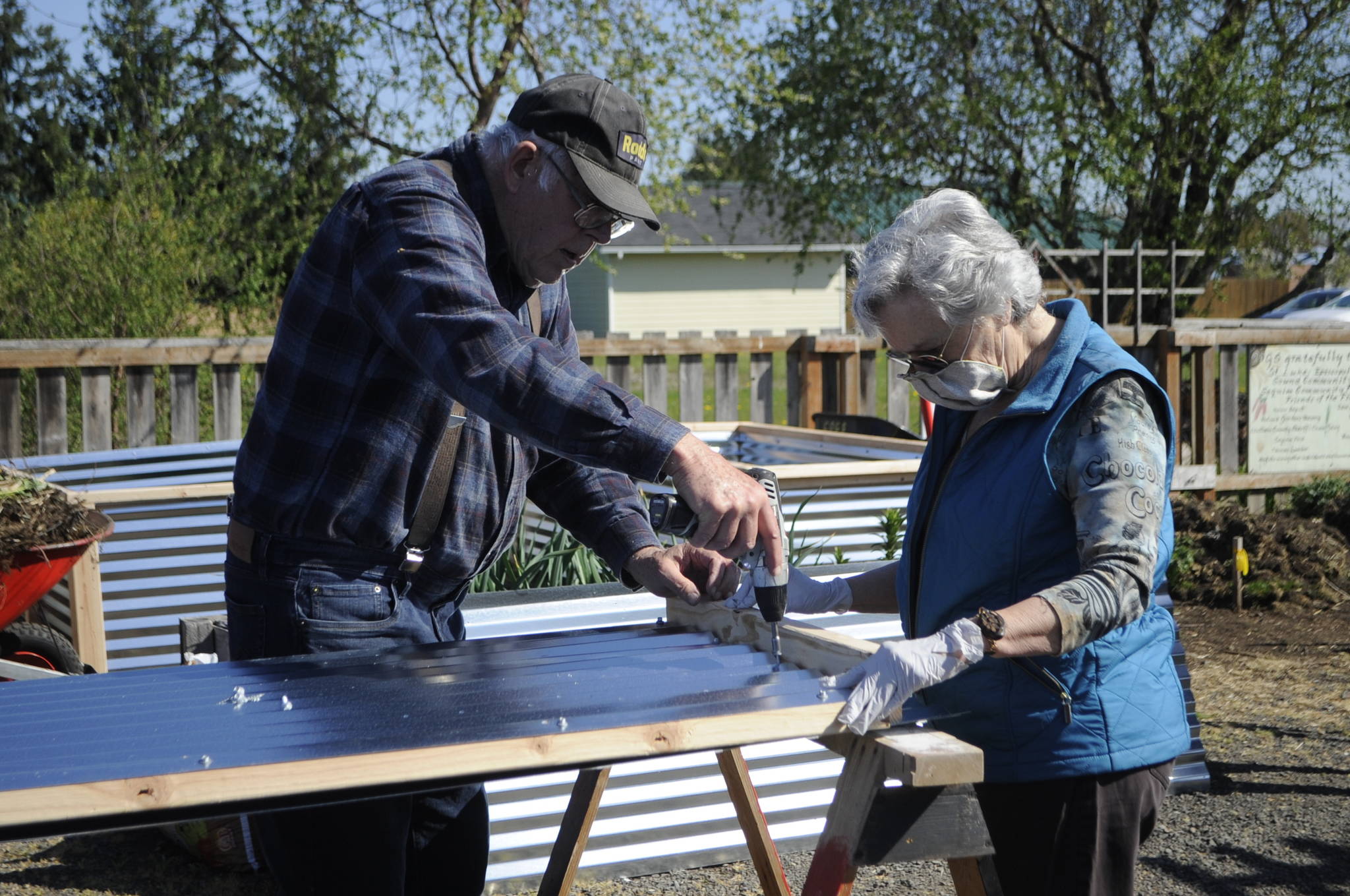 Gardeners Bob Caldwell and Sue Scott work together on April 17 to build one of the walls of a raised bed in the Fir Street Community Garden. Sequim Gazette photo by Matthew Nash