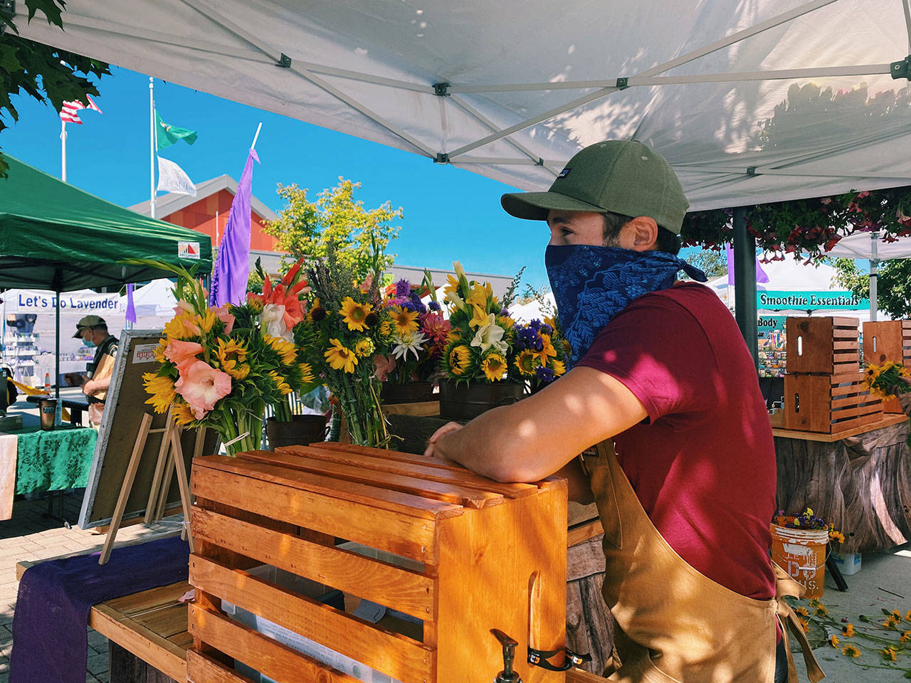 Jude Schweizer of Sativa Valley Essentials offers mixed vegetables and farm products, CBD products and fresh cut bouquets at the Sequim Farmers & Artisans Market, which opens this Saturday, May 1. Photo by Emma Jane Garcia