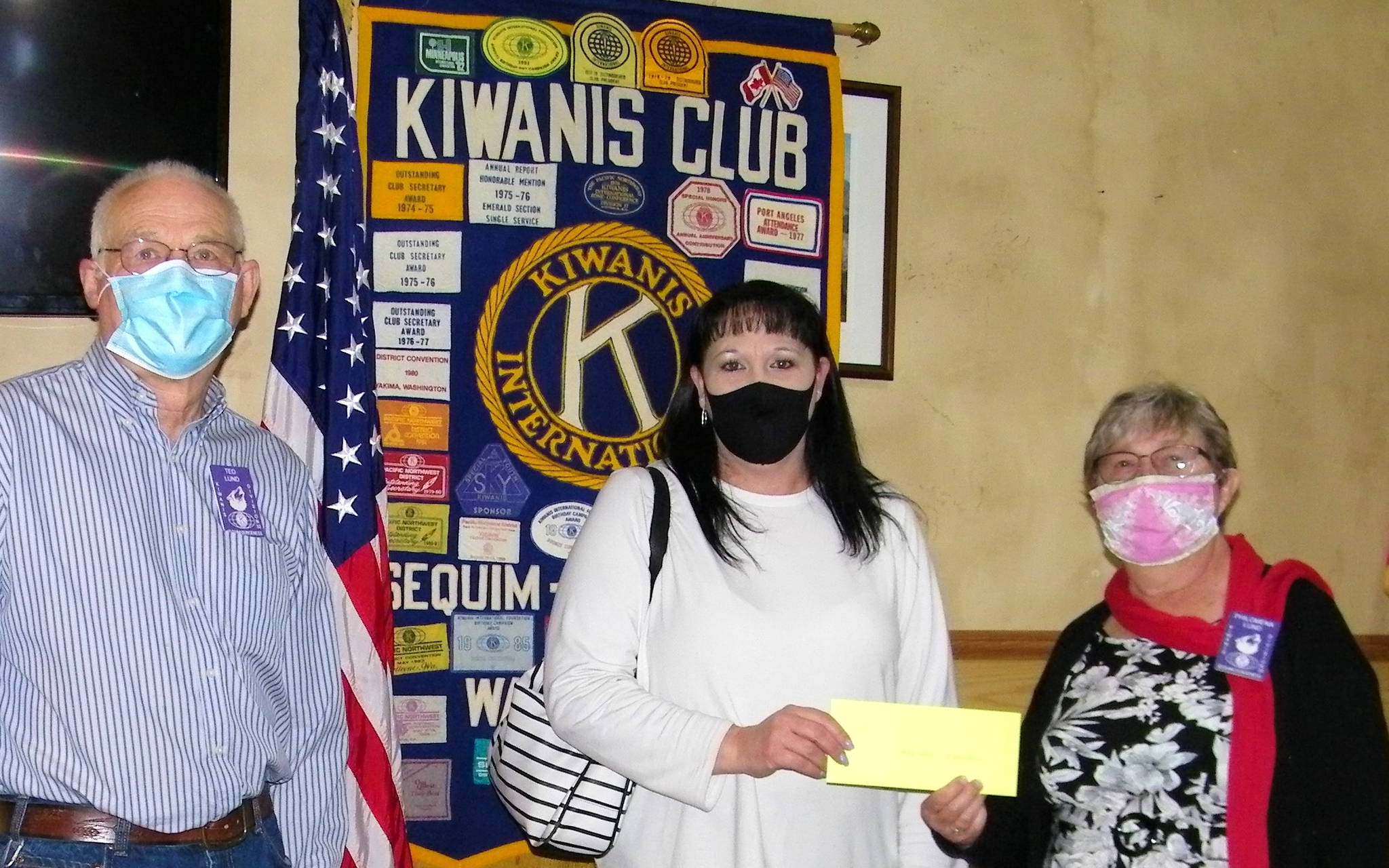 President Ted Lund, on left, and treasurer Philomena Lund of the Kiwanis of Sequim-Dungeness, on right, present Nicole Goettling, owner-director of Bibity Bobity, a check for $275 to help install a shaded area outside for learning and play as part of a Kiwanis “mini-grant” program. Submitted photo
