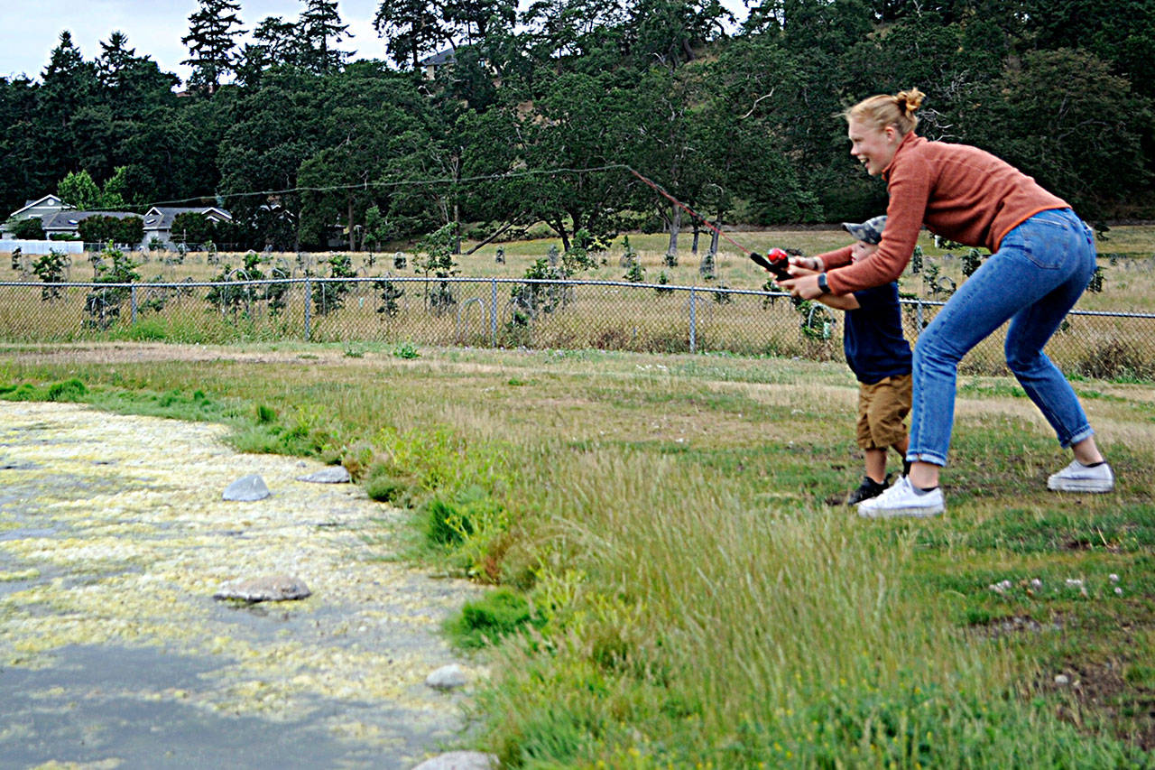 Emily Bundy helps 2-year-old cousin Charlie Nielsen of Salt Lake City, Utah, cast out at the Water Reuse Reclamation Pond on July 1. Bundy, 20, is a Sequim High grad, is studying biology on her path for pre-med at Gonzaga University. Sequim Gazette photo by Matthew Nash