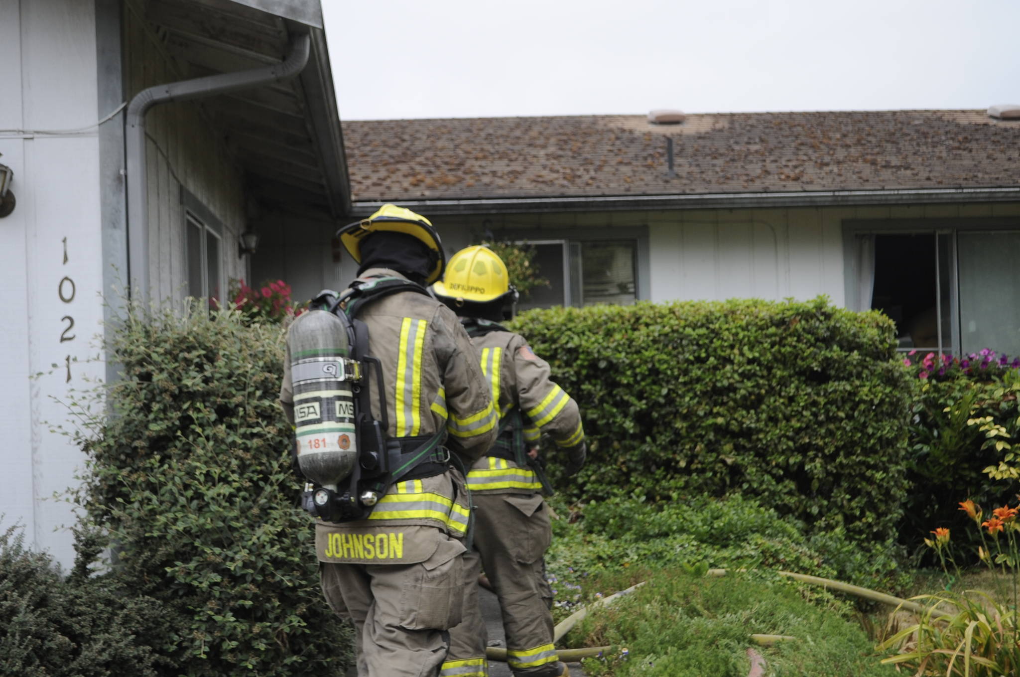 Firefighters on July 14 access a home on the 1000 block of West Palo Verde Loop to make sure a fire is extinguished. Sequim Gazette photo by Matthew Nash