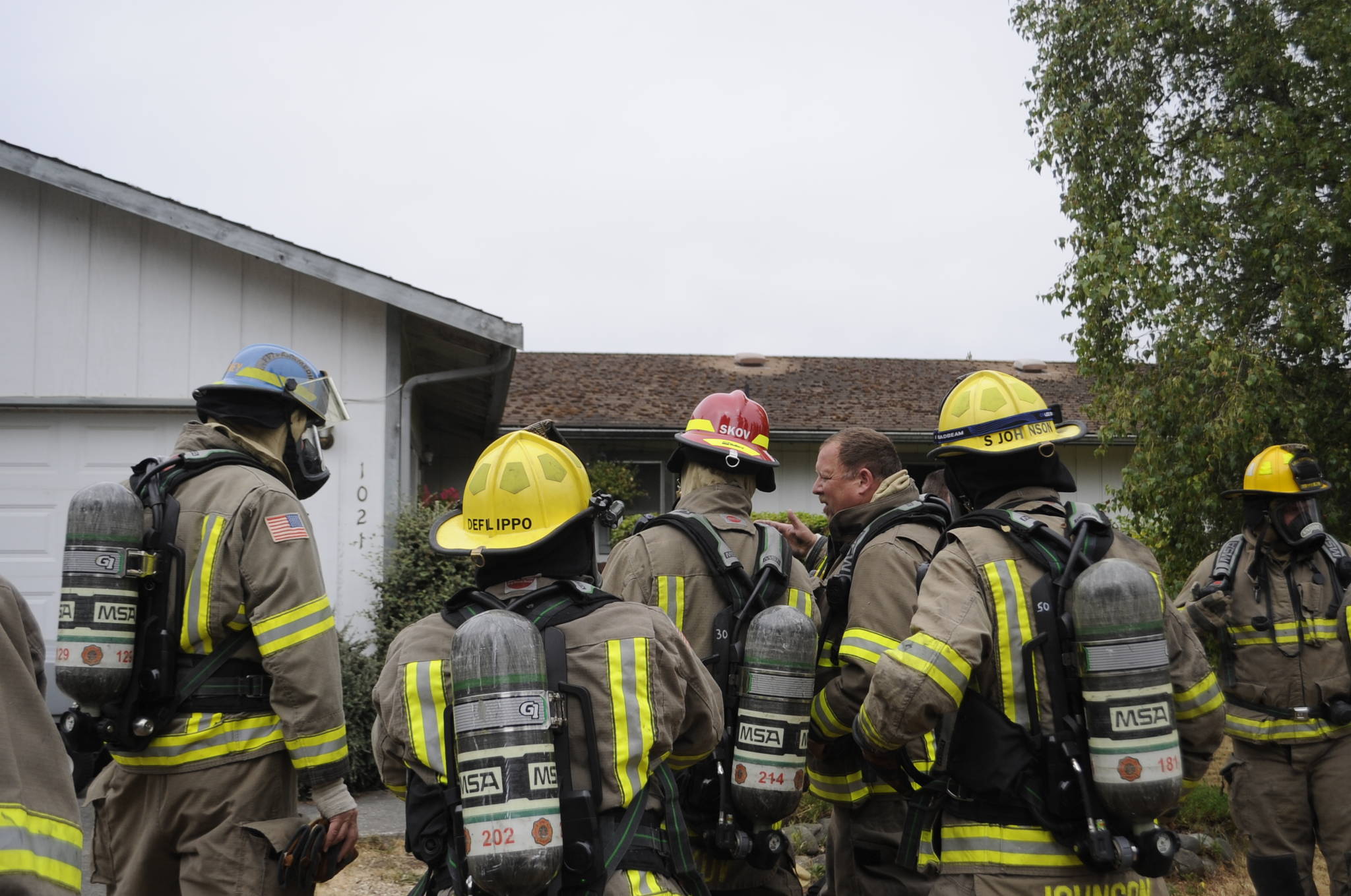 Clallam County Fire District 3 firefighters receive instruction before reentering a home on July 14 on the 1000 block of West Palo Verde Loop, where a fire started in a bathroom. Its cause is under investigation. Sequim Gazette photo by Matthew Nash