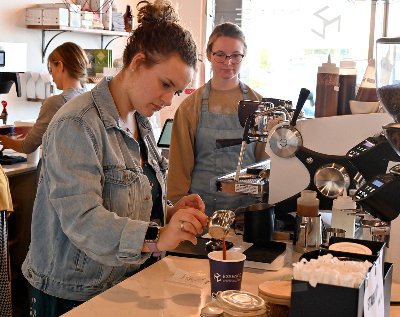 Emily Gogos makes a drink while fellow staffer Tyanna Koehn looks on at Essence Coffee Roasters’s one-year anniversary celebration on July 22. Sequim Gazette photo by Michael Dashiell