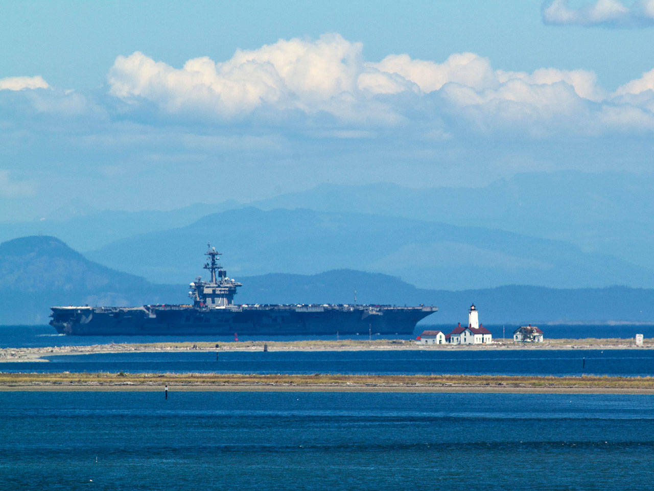 Contributor Kip Tuplin caught this image of the USS Teddy Roosevelt — a Nimitz-class, nuclear-powered, aircraft carrier — as it passes the New Dungeness Lighthouse on July 22. The U.S. Navy ship, along with 2,500 sailors and their families, are calling the Puget Sound their new home for the next year and a half at Naval Base Kitsap in Bremerton.