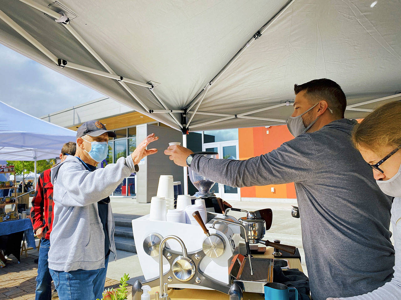 Essence Coffee Roasters’ Rod Dirks hands a customer their coffee at the Sequim Farmers & Artisans Market. Photo by Emma Jane “EJ” Garcia