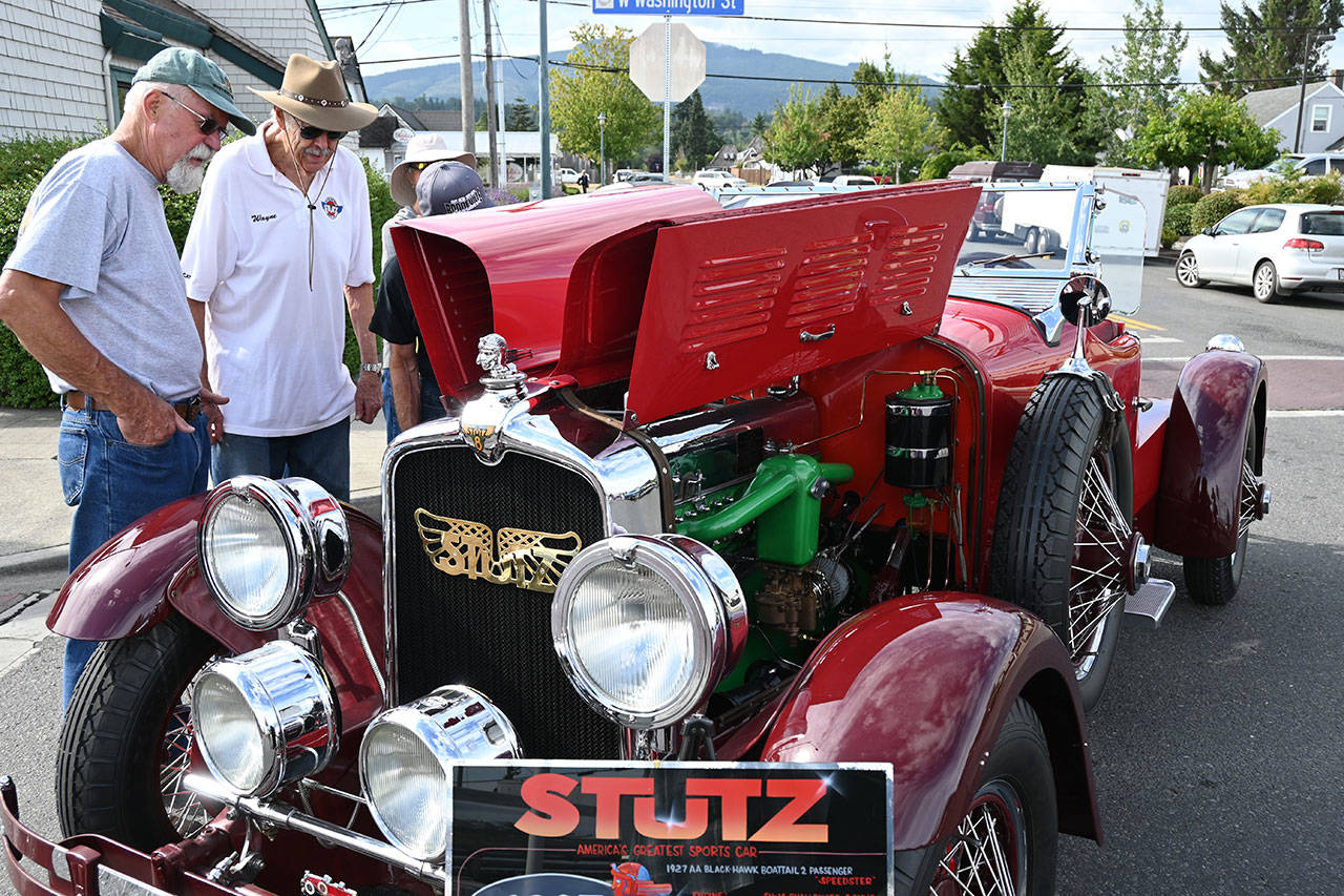 Wayne Caldwell of Sequim, second from left, discusses his Stutz sports car, a 1927 AA Black-Hawk boat-tail two-passenger speedster, with attendees of the Sequim Prairie Nights event in downtown Sequim Saturday. Sequim Gazette photos by Michael Dashiell