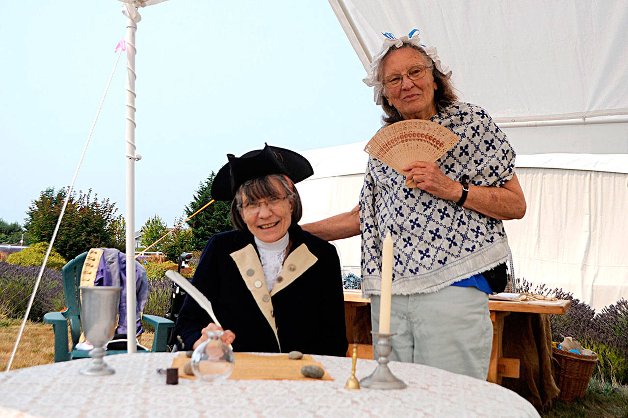 Linda Brocklesby, sitting, and her mom Kris Trexler of Sequim ready for a photo-op with the Constitution of the United States during the Northwest Colonial Festival. Sequim Gazette photos by Matthew Nash