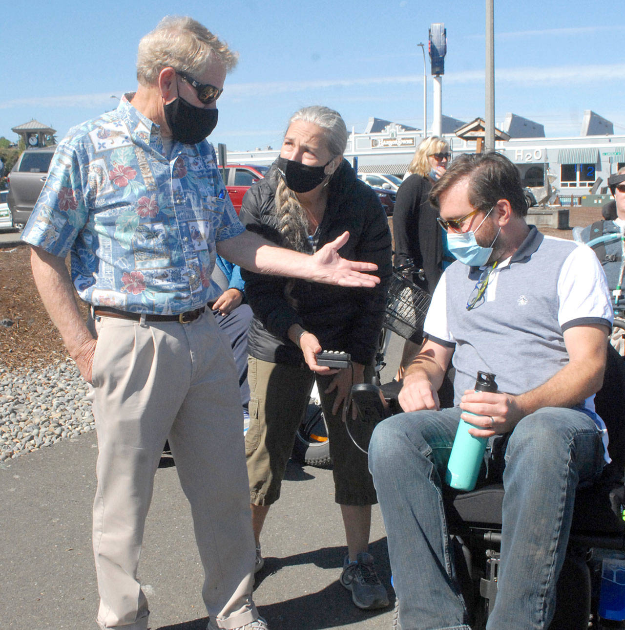 Clallam County Commissioner Randy Johnson, left, speaks with Jefferson County Commissioner Greg Brotherton, seated, as the pair receive motorized wheelchair advice 
Aug. 28 from Teena Woodward, mother of Ian Mackay, founder of Ian’s Ride. Photo by Keith Thorpe/Olympic Peninsula News Group