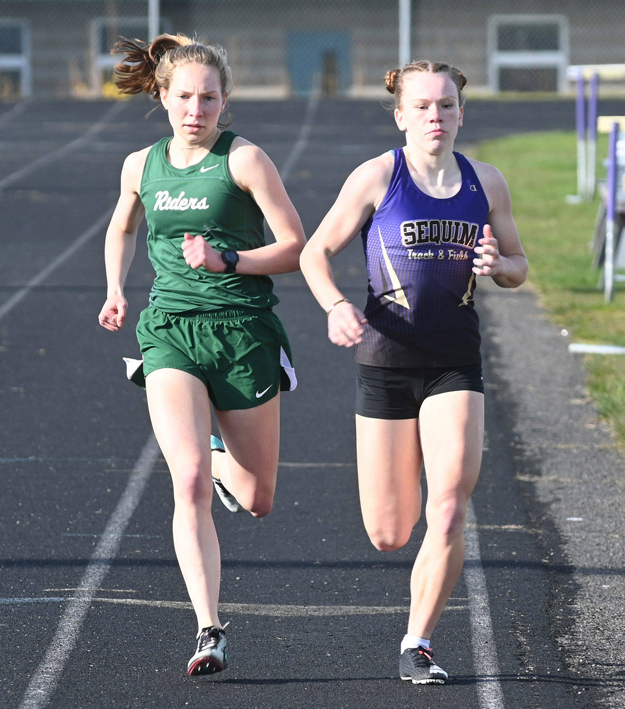 A classic Sequim-Port Angeles match-up that didn’t get to shine on the state level last year: PA and Sequim standouts Lauren Larson and Riley Pyeatt go toe-to-toe in the 800-meter race on March 31 in Sequim. The pair competed in same races more than a dozen times, but health restrictions nixed a chance for both to vie for district and state titles in 2020-2021. Larson graduated in 2021, while Pyeatt looks for strong finishes in cross country and track in 2021-2022, her senior year. Sequim Gazette file photo by Michael Dashiell