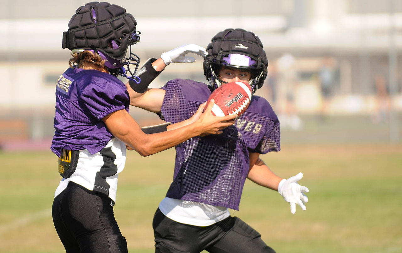 Sequim quarterback Kobe Applegate, left, hands off to running back Aiden Gockerell in a preseason practice last week. The Wolves play their first game on Sept. 3 at Forks. Sequim Gazette photos by Michael Dashiell