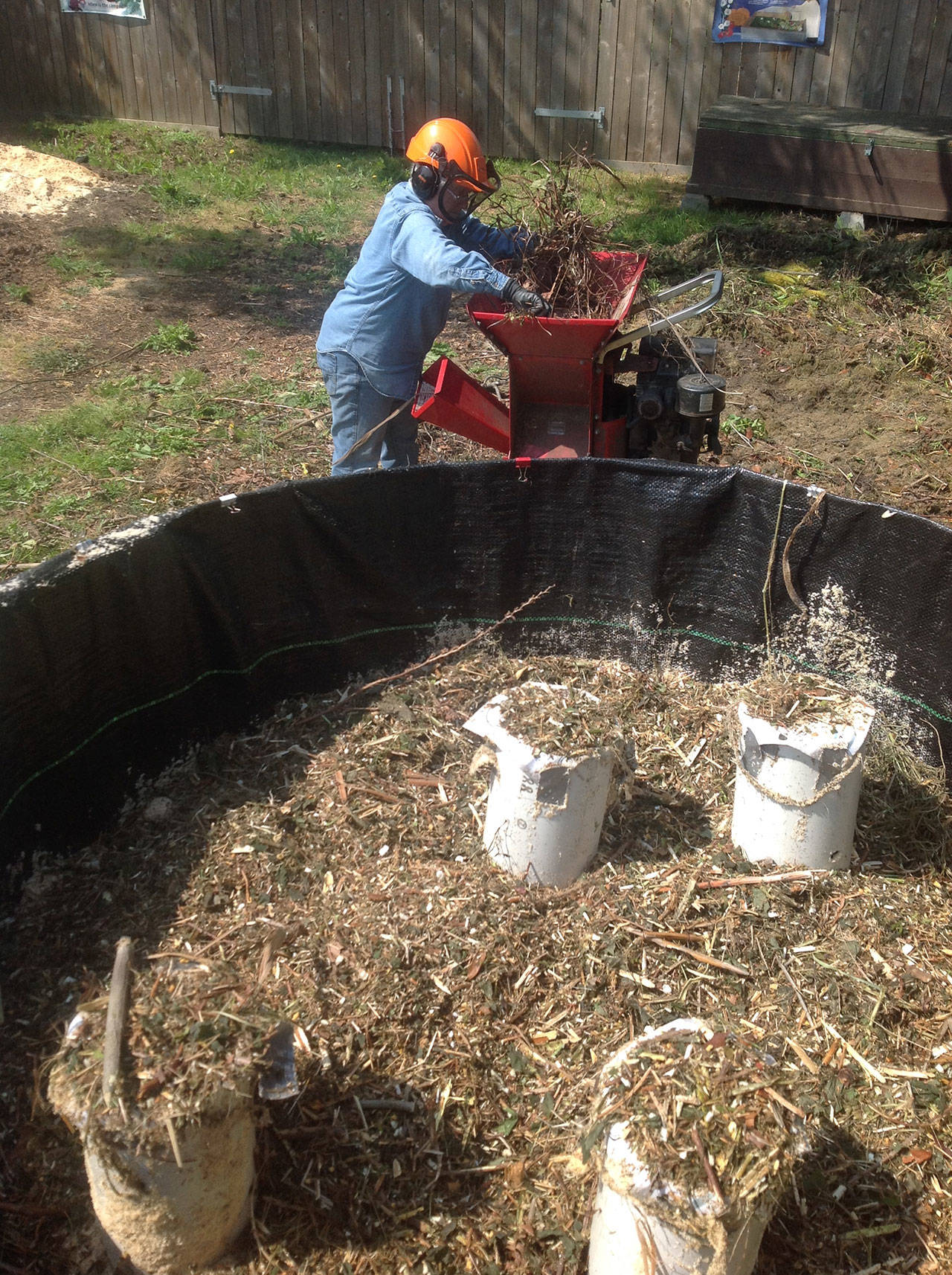 Al Cairo prepares shredded garden waste and fills the Johnson-Su composting bioreactor at Woodcock Garden. Photo courtesy of Al Cairo
